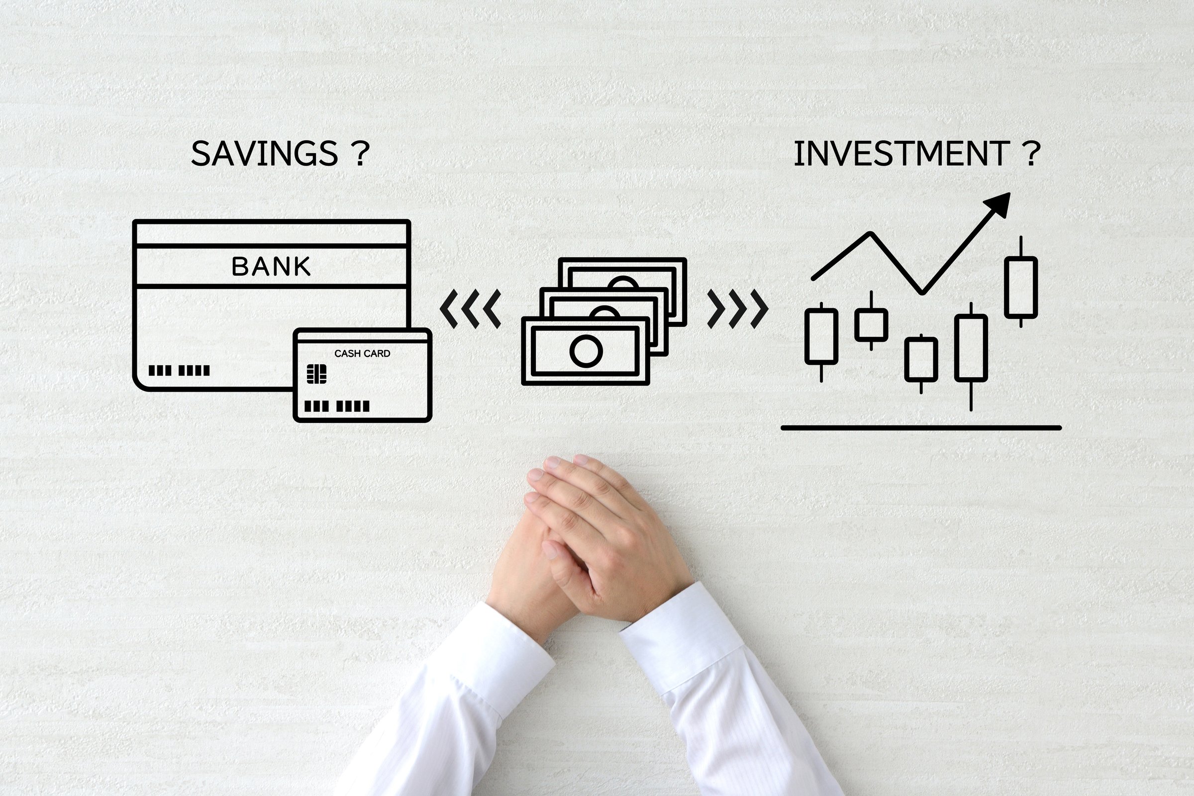 Hands of someone wondering whether to save or invest money