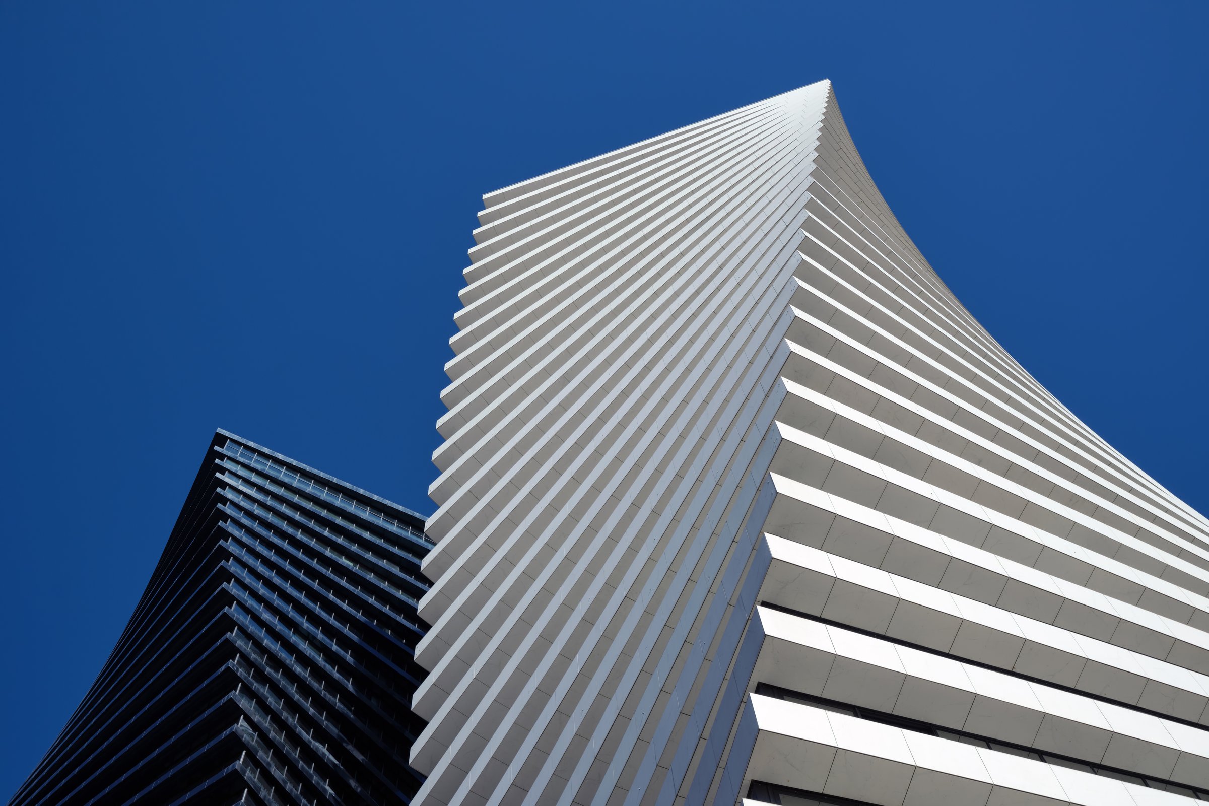 Bottom view of the black tower of skyscrapers Axis Towers Art Nouveau building against the backdrop of a beautiful clean sky on Chavchavadze Avenue: Tbilisi, Georgia - March 7, 2023.