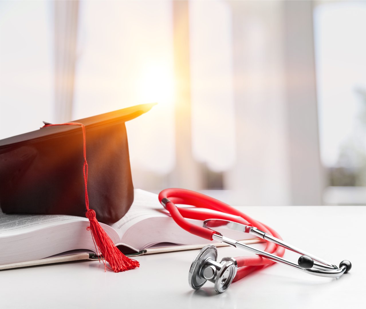 Stethoscope and graduate hat with book