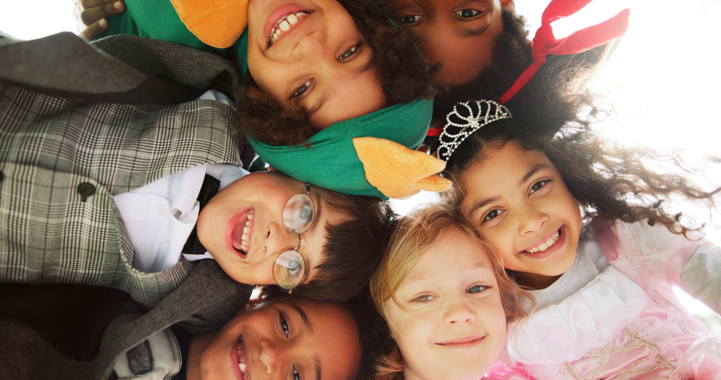 Below, portrait and children with costumes outdoor for Halloween party, celebration and bonding. Huddle, kids and smile with character outfits for spooky season, cosplay holiday and friends together