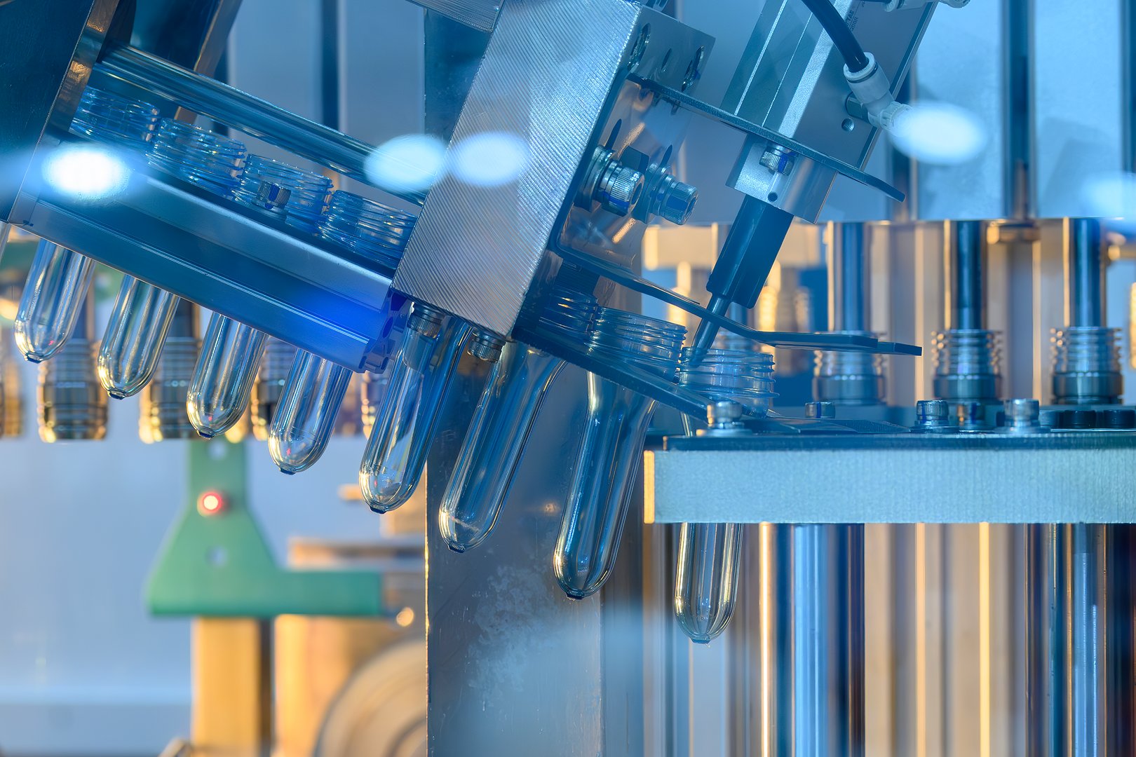 Close up scene the plastic bottle preform shape on the conveyor belt in the blue scene. The drinking water bottle manufacturing process by blow mold machine.