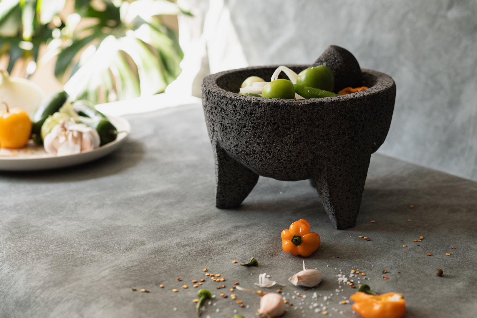 rustic table with the ingredients ready to prepare a Mexican sauce, on the table are sprinkled ingredients such as garlic, chillies, grain salt.