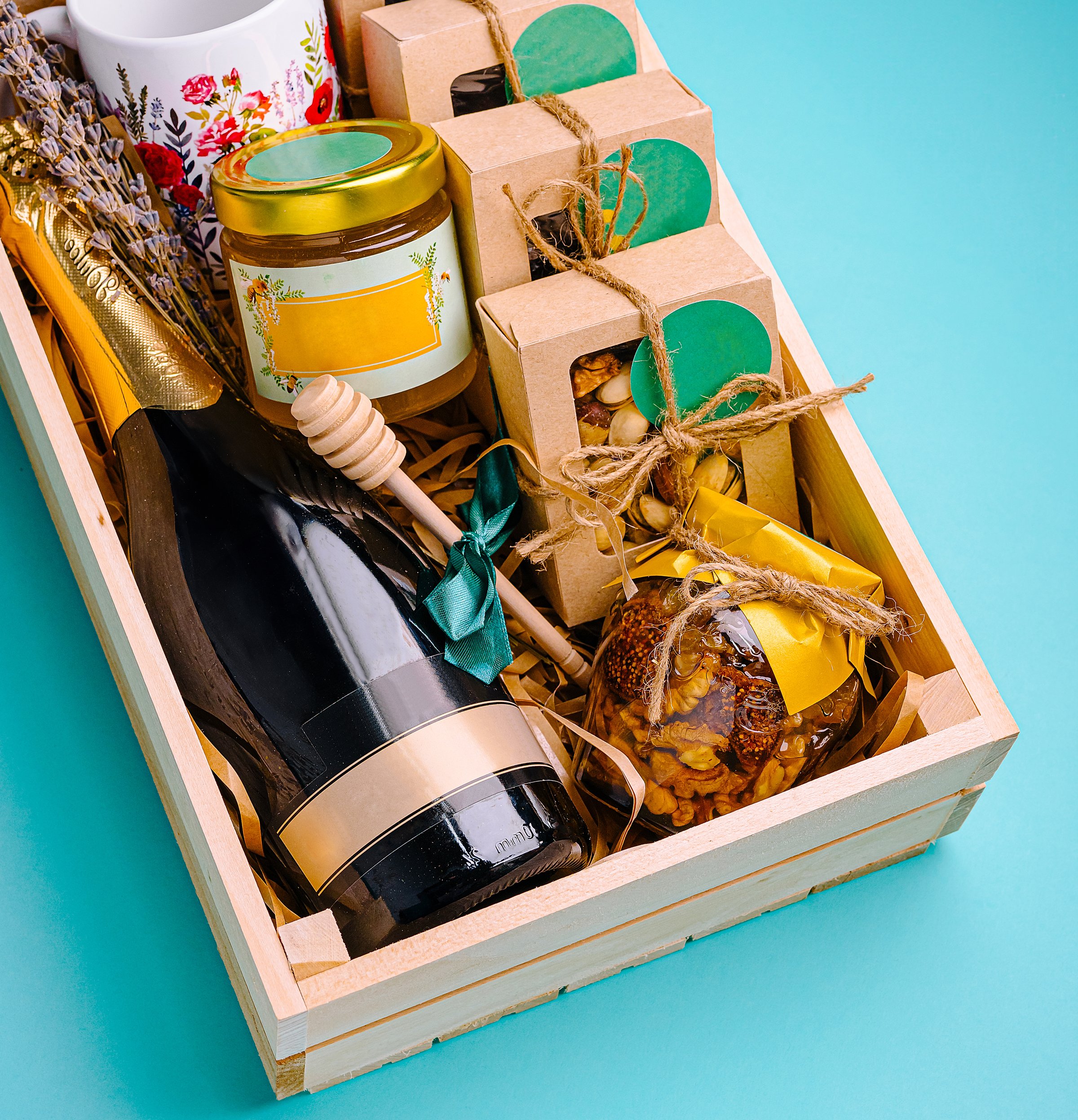This vibrant gift basket showcases a bottle of champagne, assorted snacks, and a decorative mug, all arranged thoughtfully for a festive occasion or celebration.