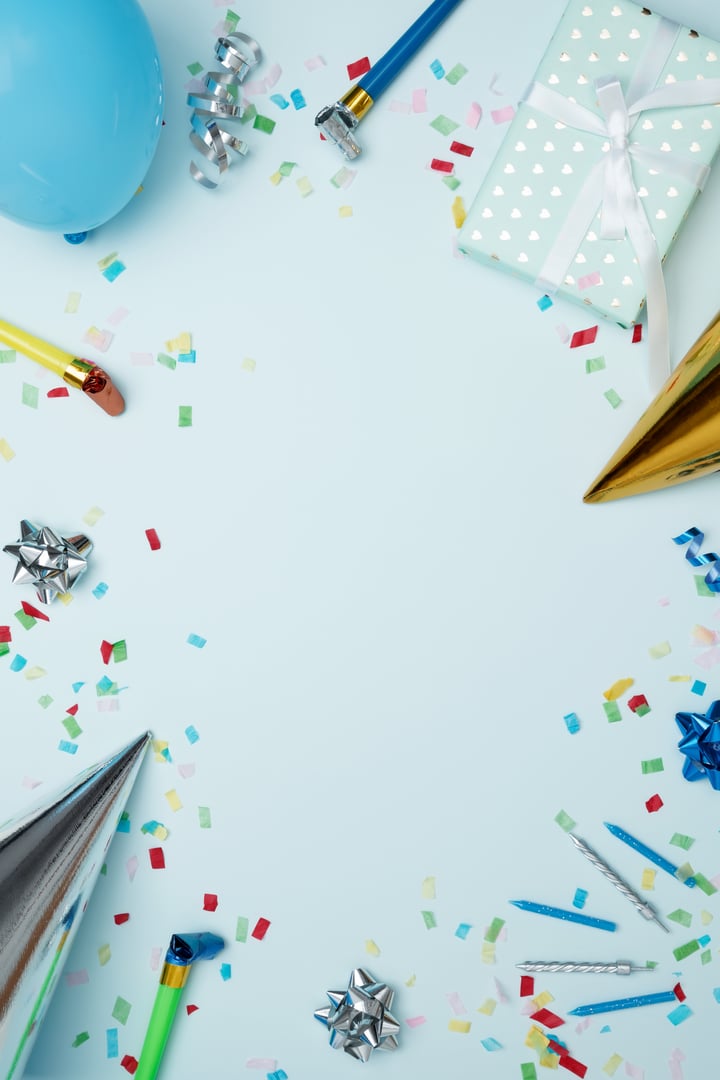 Concept of festive birthday celebrations. Birthday attributes colorful balloons, party hats, candles, confetti