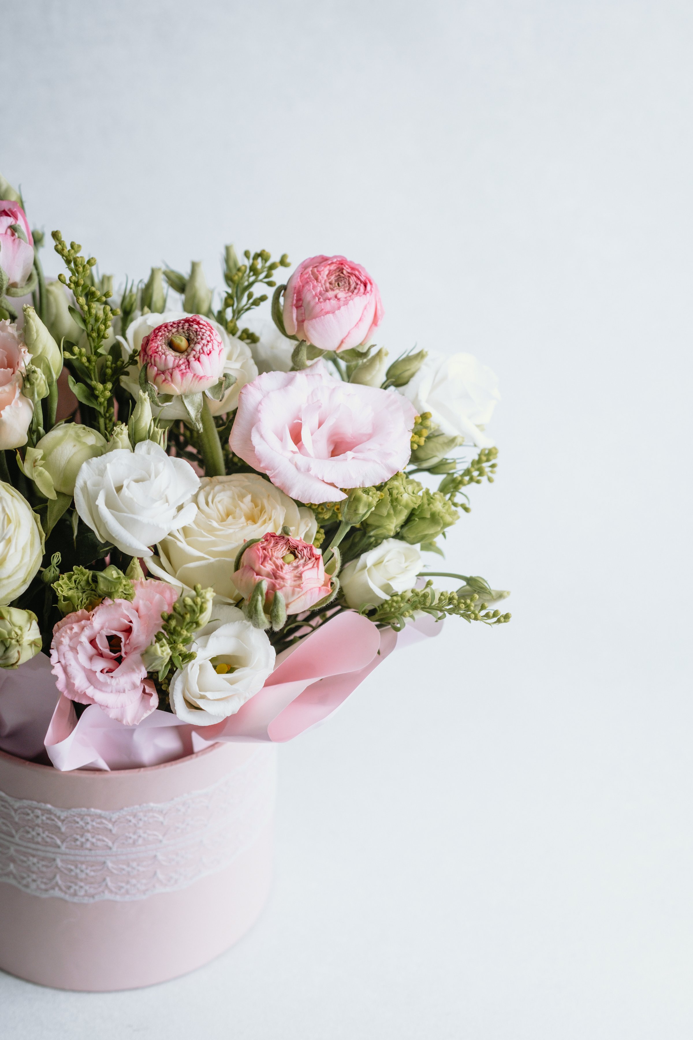 Freshly arranged pastel flowers in a pot, showcasing pink and white blooms.