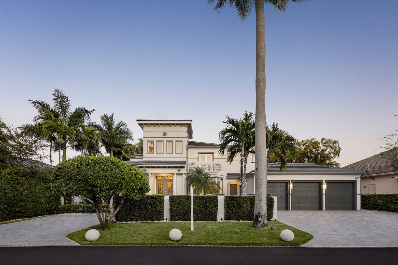 Front view of a luxury residence in a peaceful residential area. Modern architecture with classic details, lush garden, and elegant atmosphere. Exclusive upscale neighborhood setting.