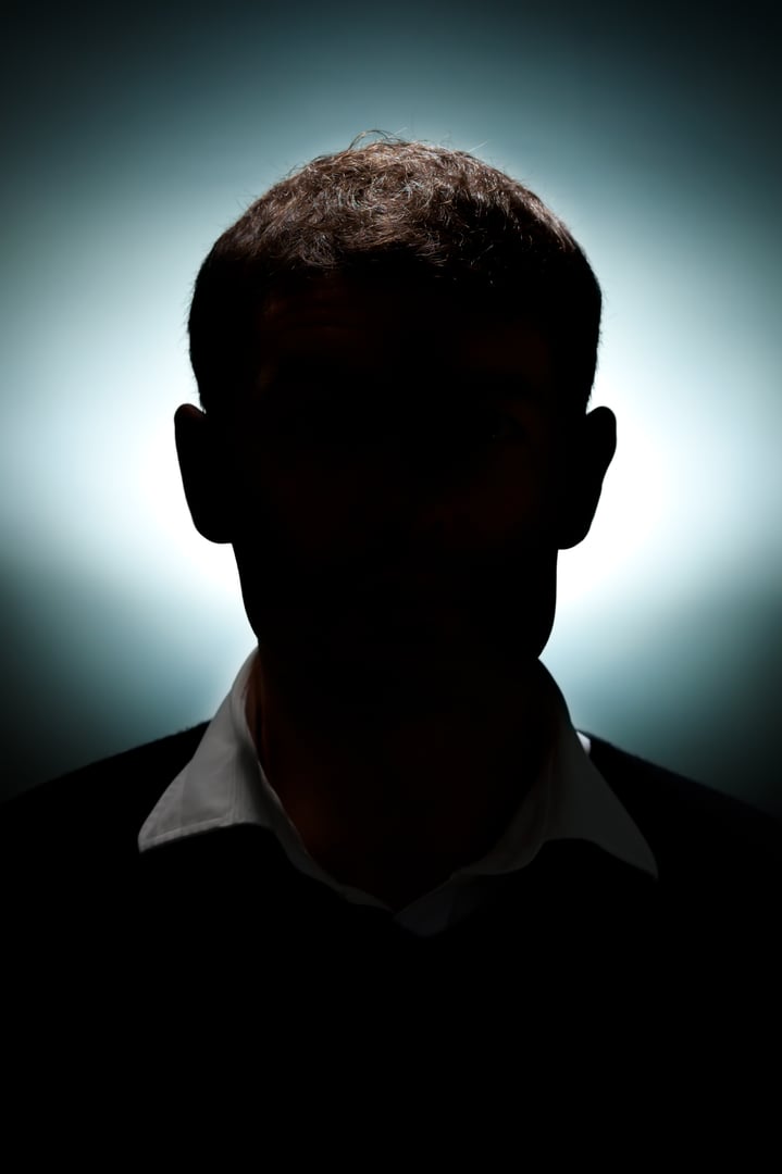 A portrait of a man lit with only a hair light and a background light.