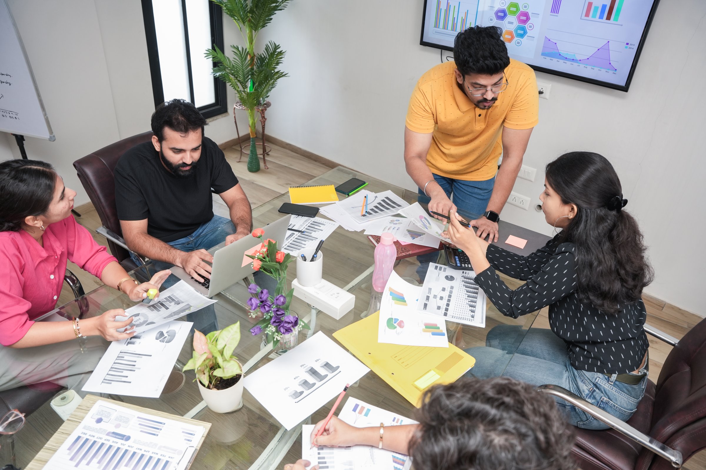 Professional young indian man Entrepreneur discussing strategy for business growth with colleagues in meeting room with financial charts and diagram. analysis, planning and sales concepts.