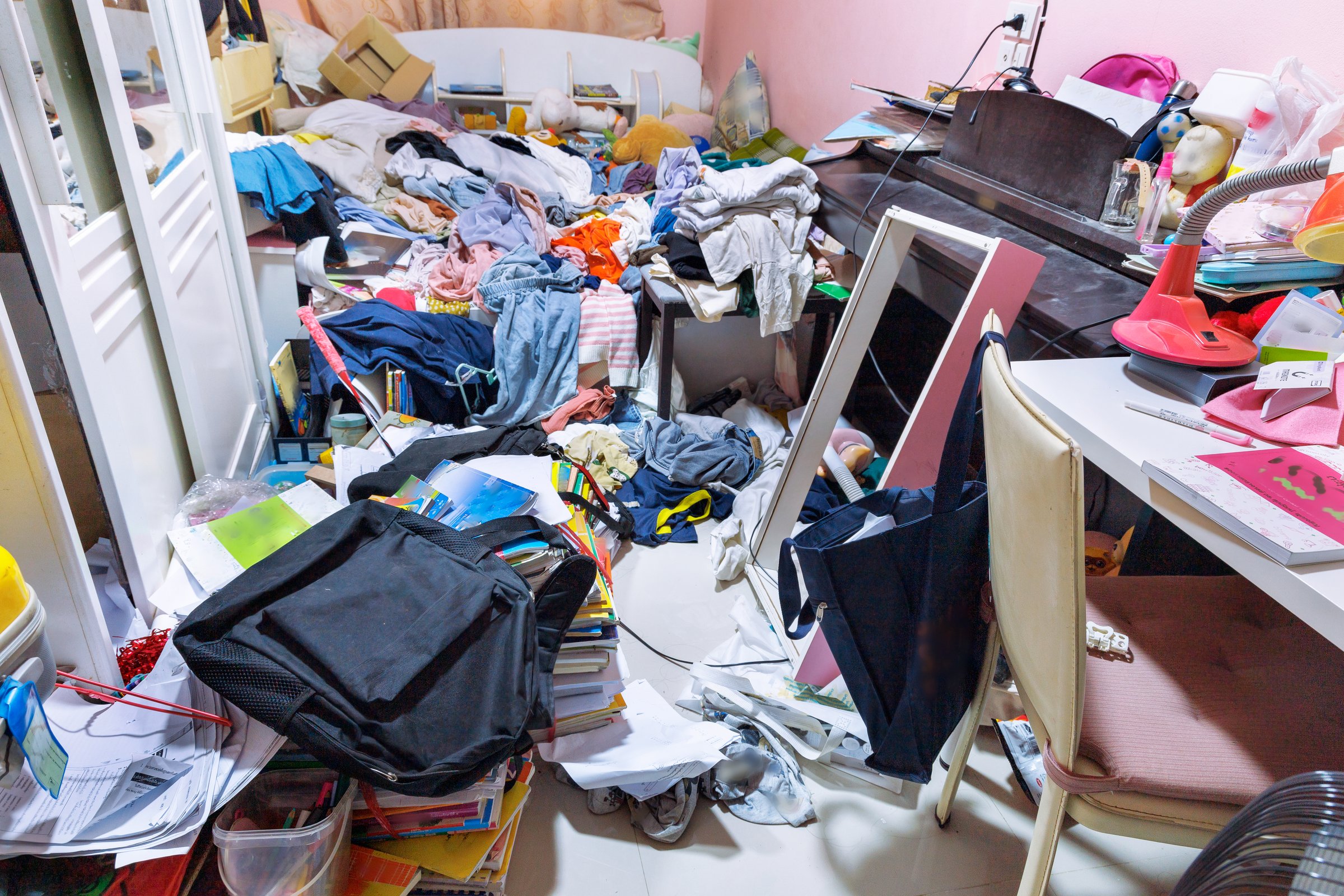 A room cluttered with piles of clothes