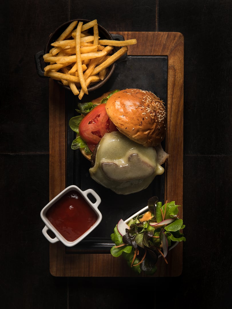 Delicious fresh tasty home cooking beef burger with cheese and french fries on wooden table, top view