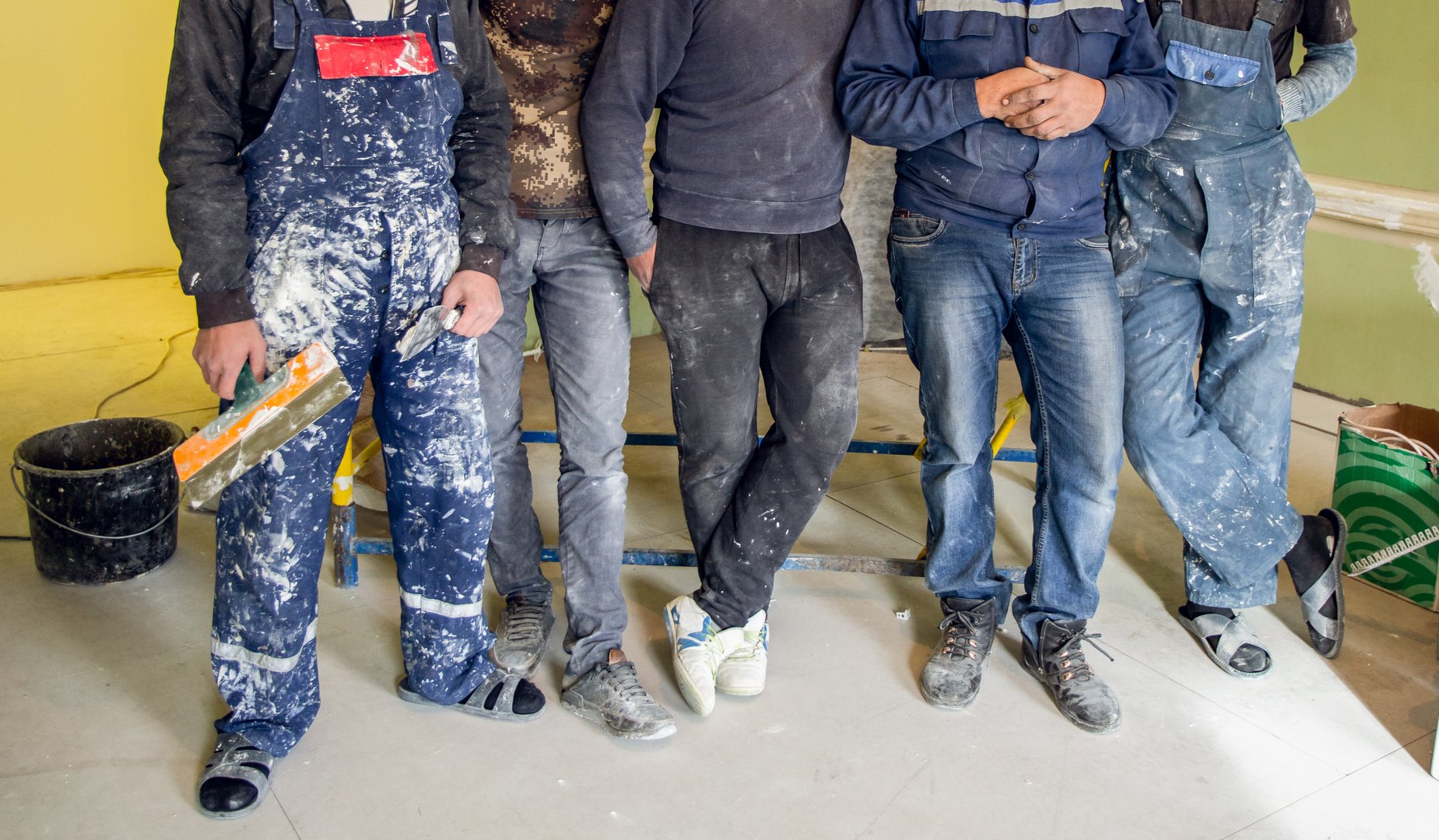 Workers and builders and foreman are as gang with dirty uniform are staying in apartment that is under construction, remodeling,renovation,extension, restoration, overhaul and reconstruction.