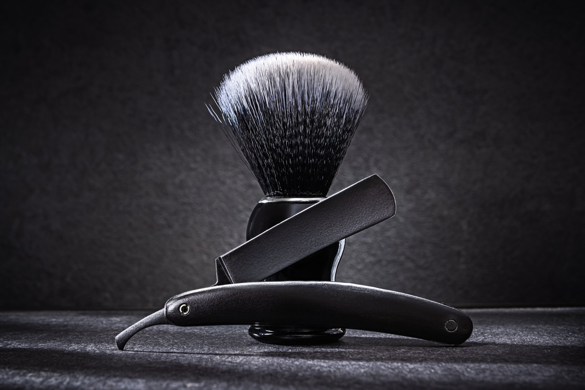 Black Straight Razor And Shaving Brash On Dark Background Close Up