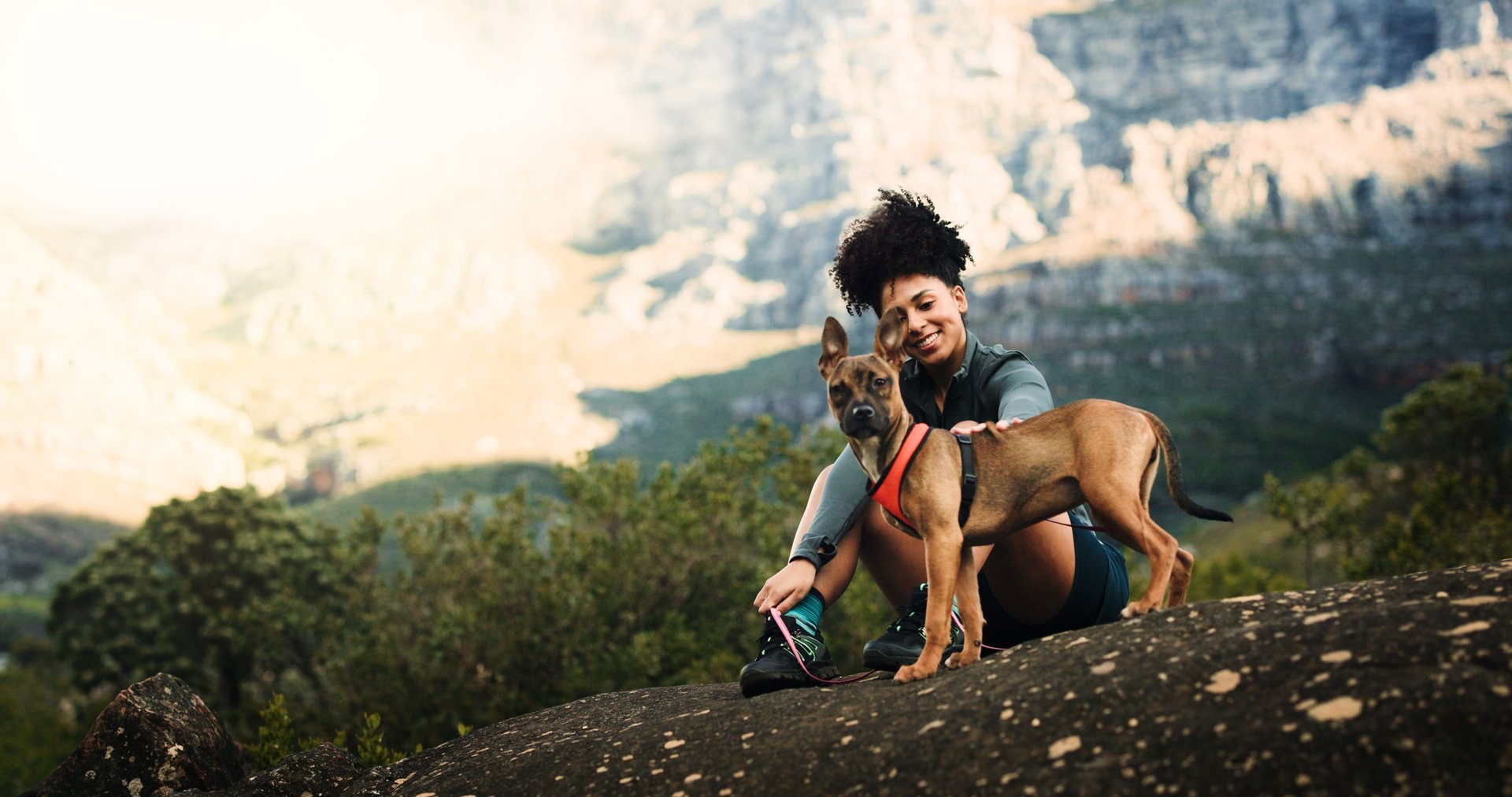 Portrait, woman and hiking with dog on mountain for travel, morning exercise and trekking break. Smile, female person and relax with pet companion, tourism adventure and fresh air of vacation bonding