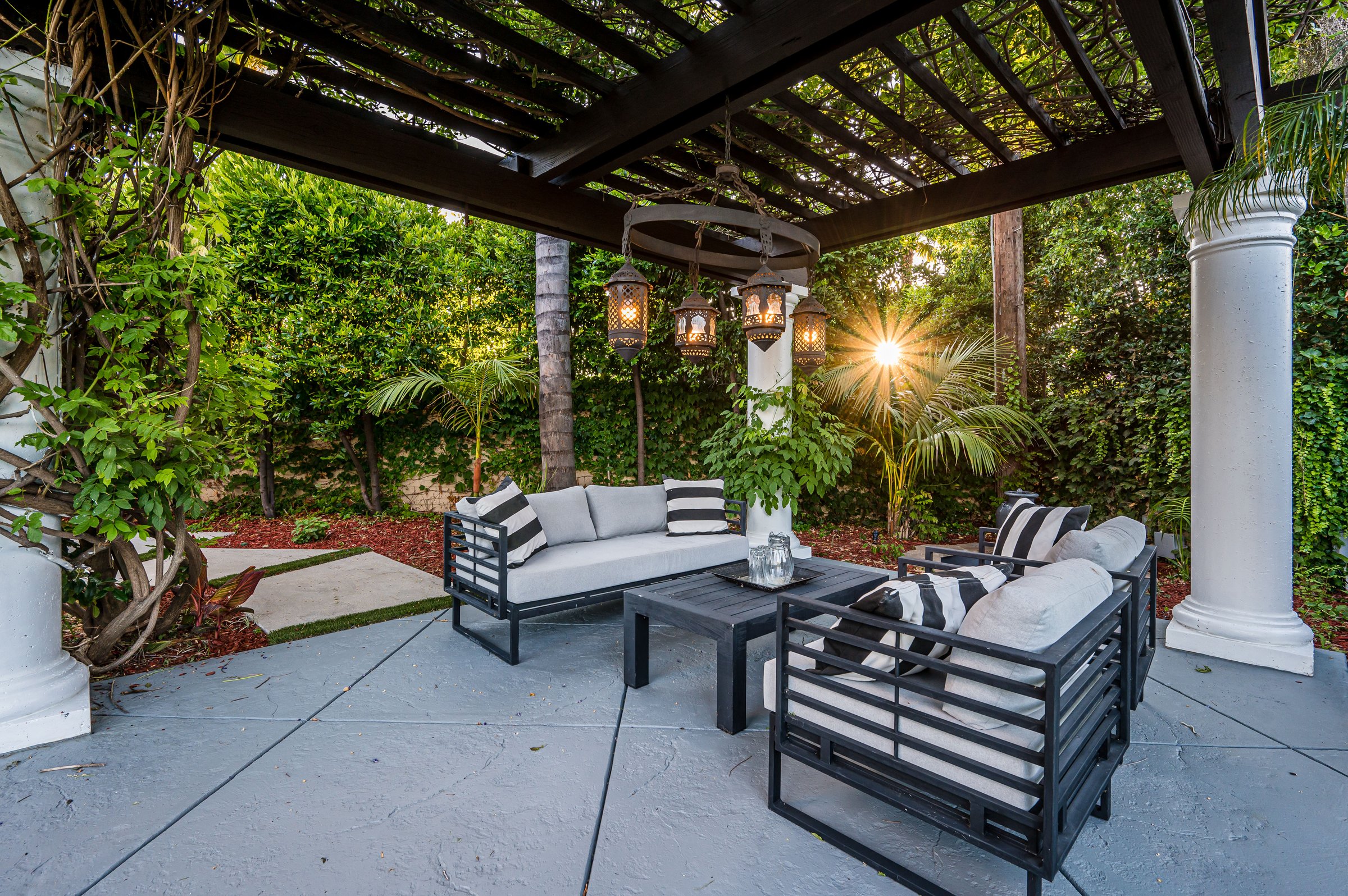 A patio with white couches and chairs in a modern new construction home in Los Angeles