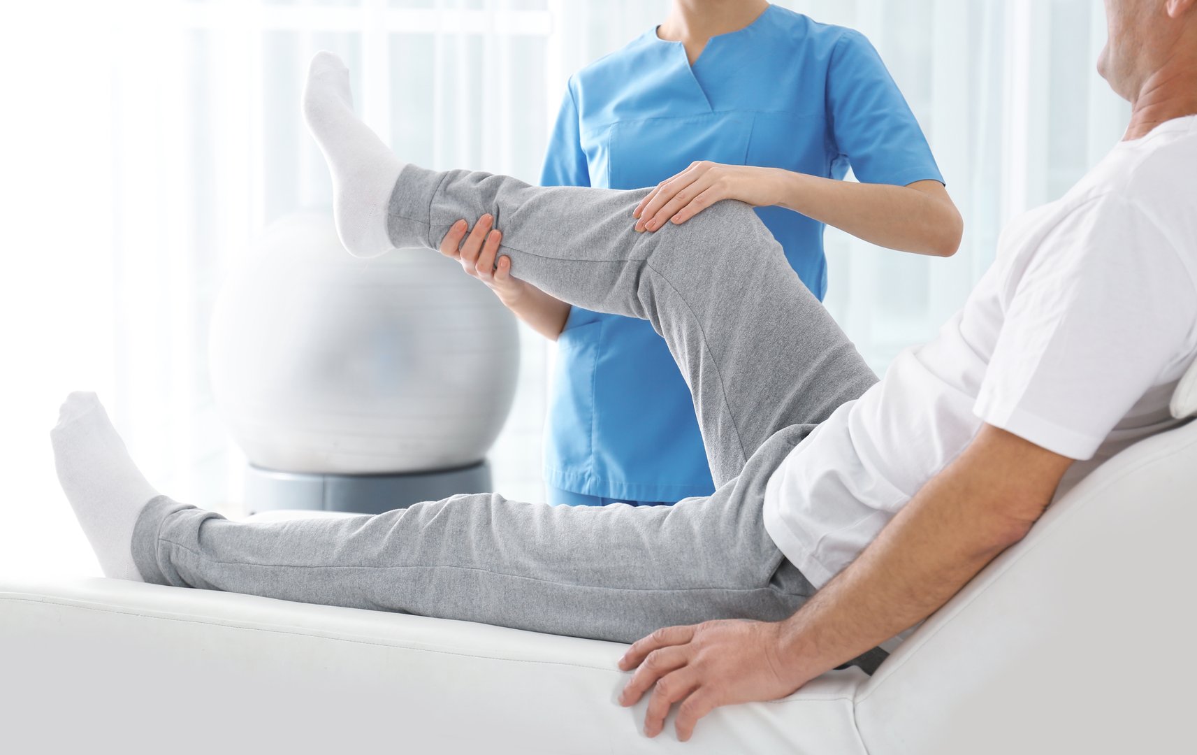 Physical Therapy: Therapist Assisting Patient with Leg Exercises.