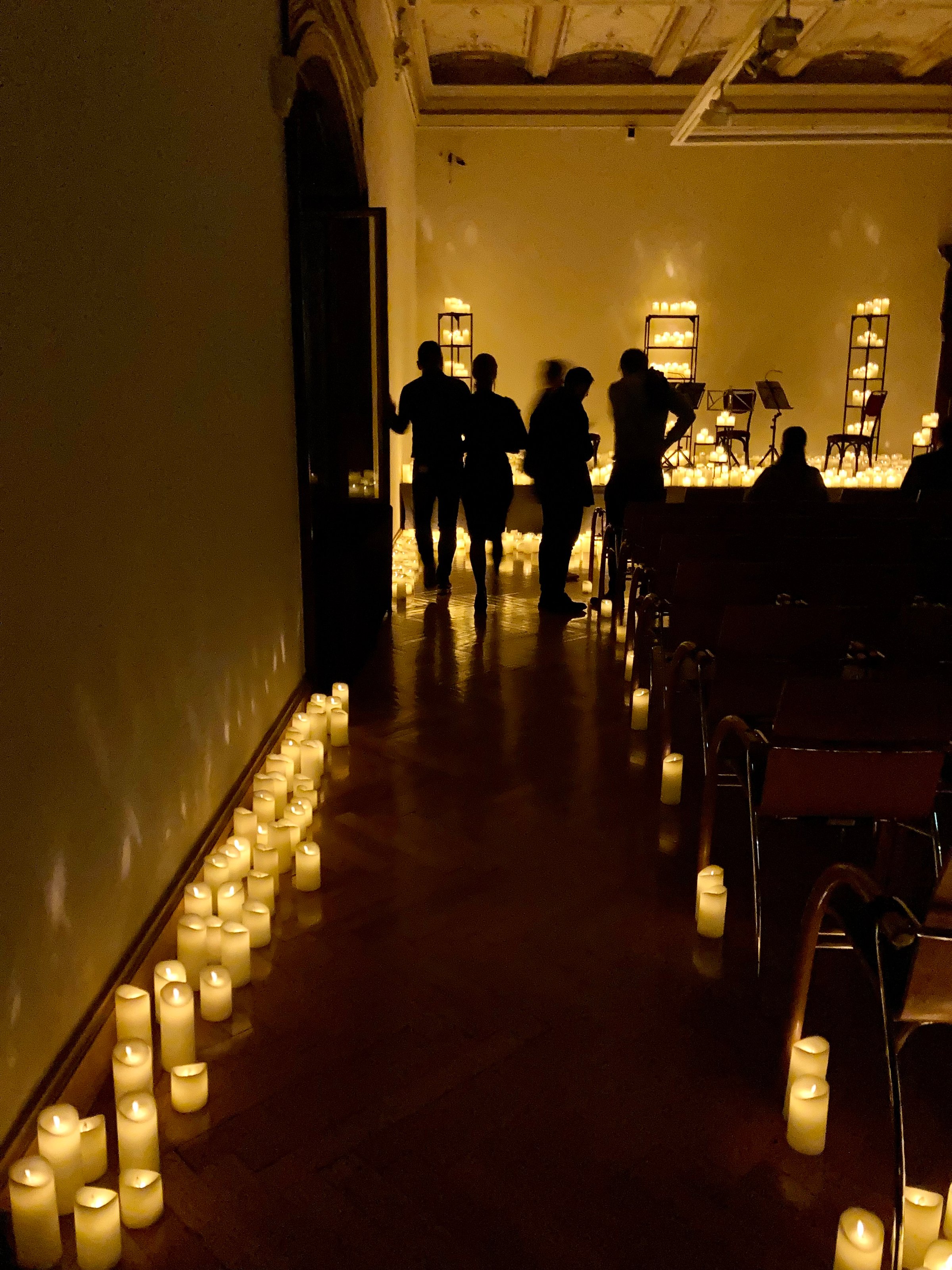 Inside the room with many candles along the aisle and on stage