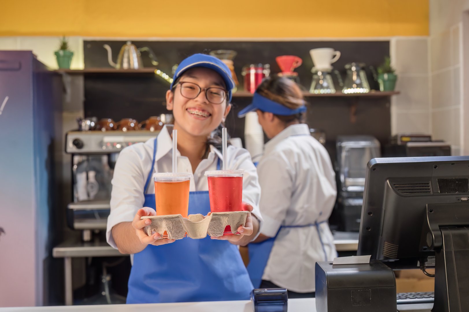 Latina girl is friendly and smiles at the customer who has come to buy some delicious and refreshing drinks.