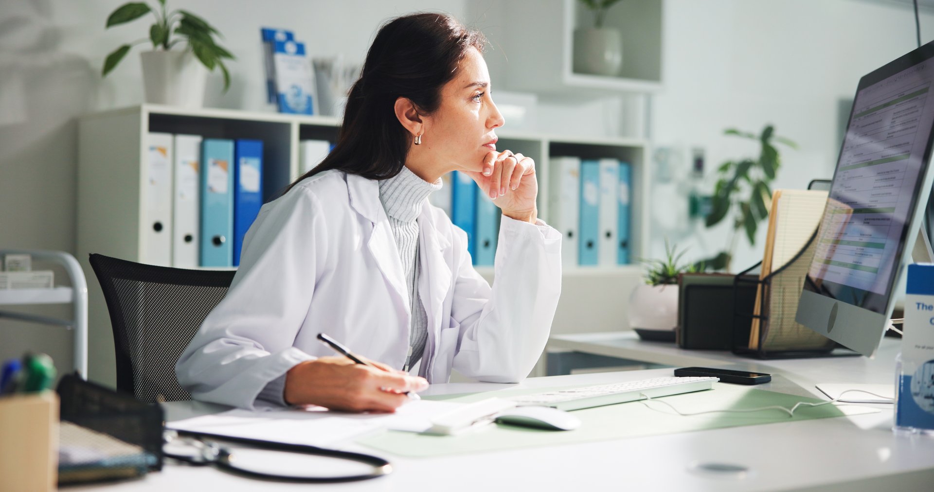 Computer, woman and doctor thinking with report in clinic for research, diagnosis or treatment. Tech, medical service and female healthcare worker with document for paperwork in hospital office