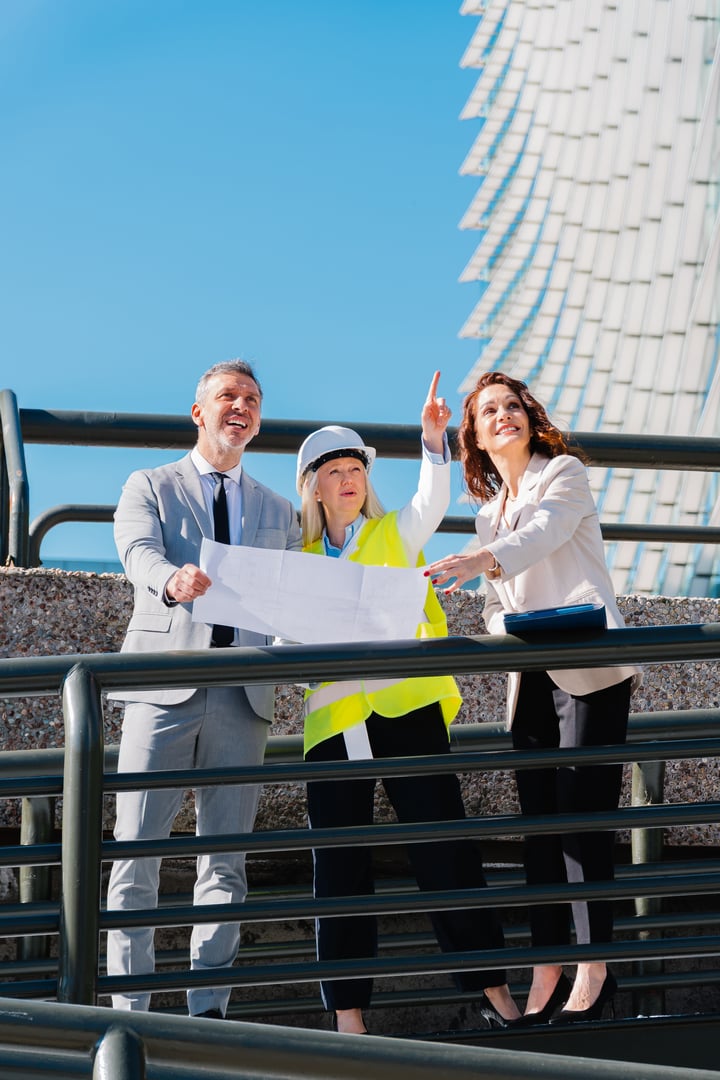 Architects and engineer examining blueprints and discussing a project