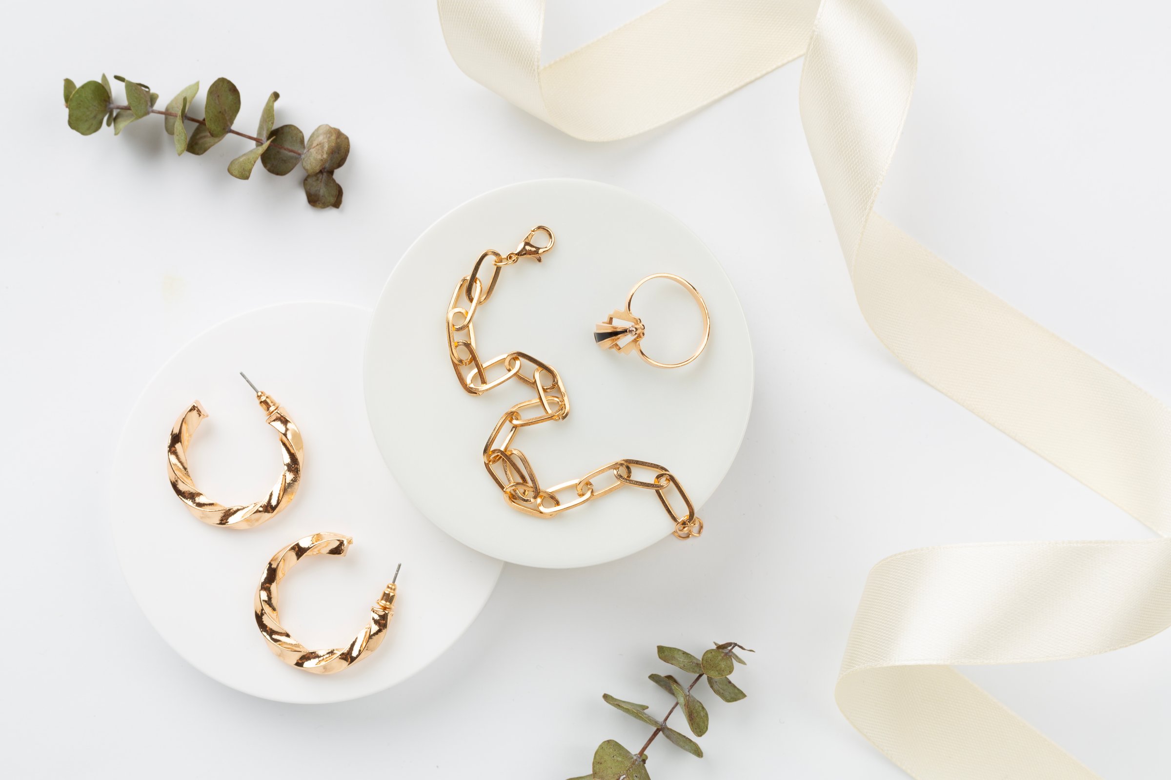 Elegant golden jewelry with decoration on color background, top view