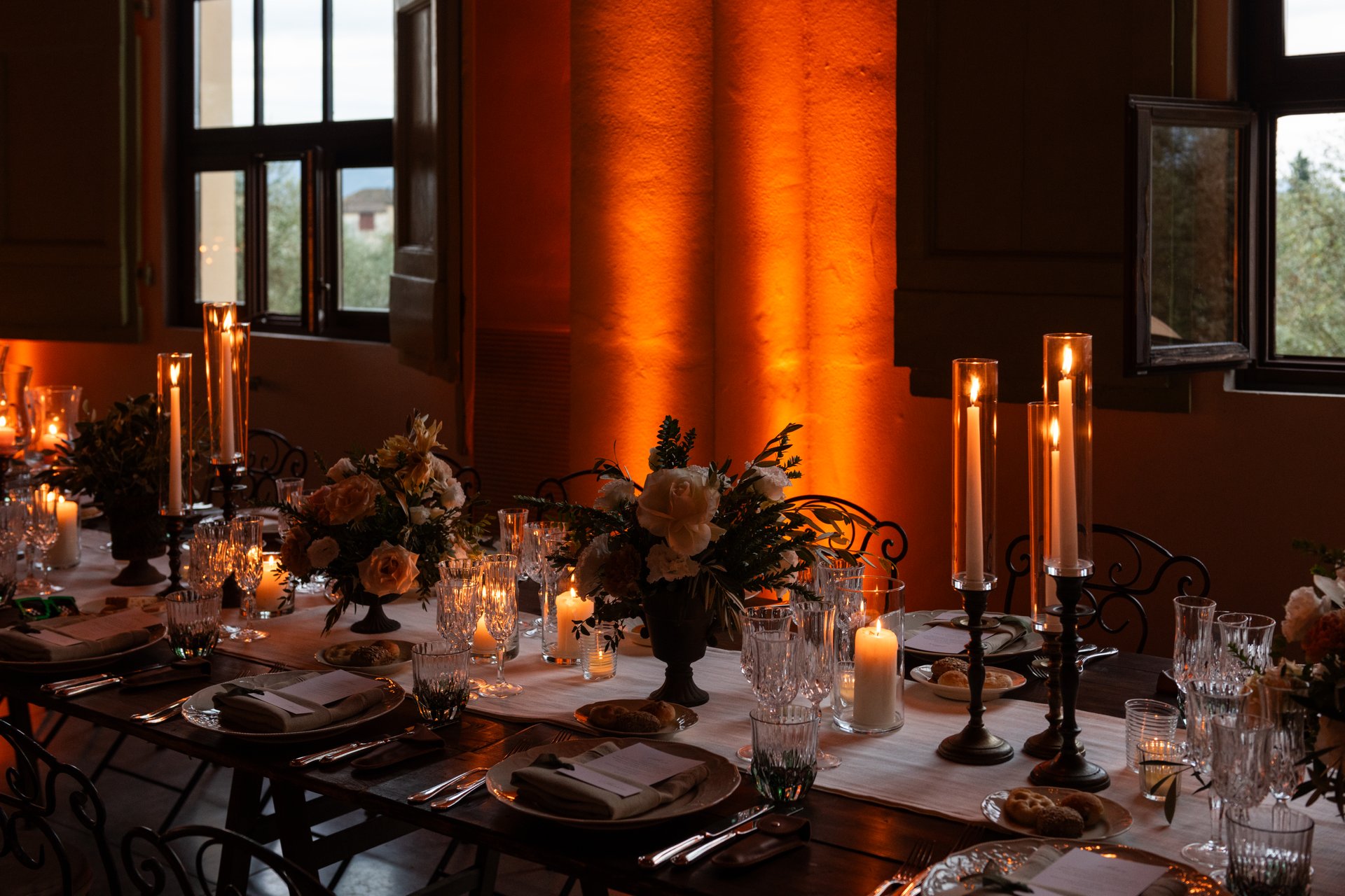 Candlelight and soft lighting provide a warm and romantic atmosphere in the banquet hall for a large destination Italian wedding.