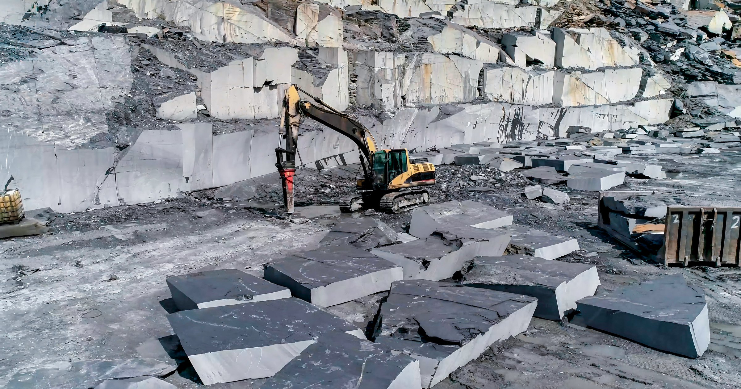 Mining machinery extracting ornamental rock in a quarry working on sidewalks