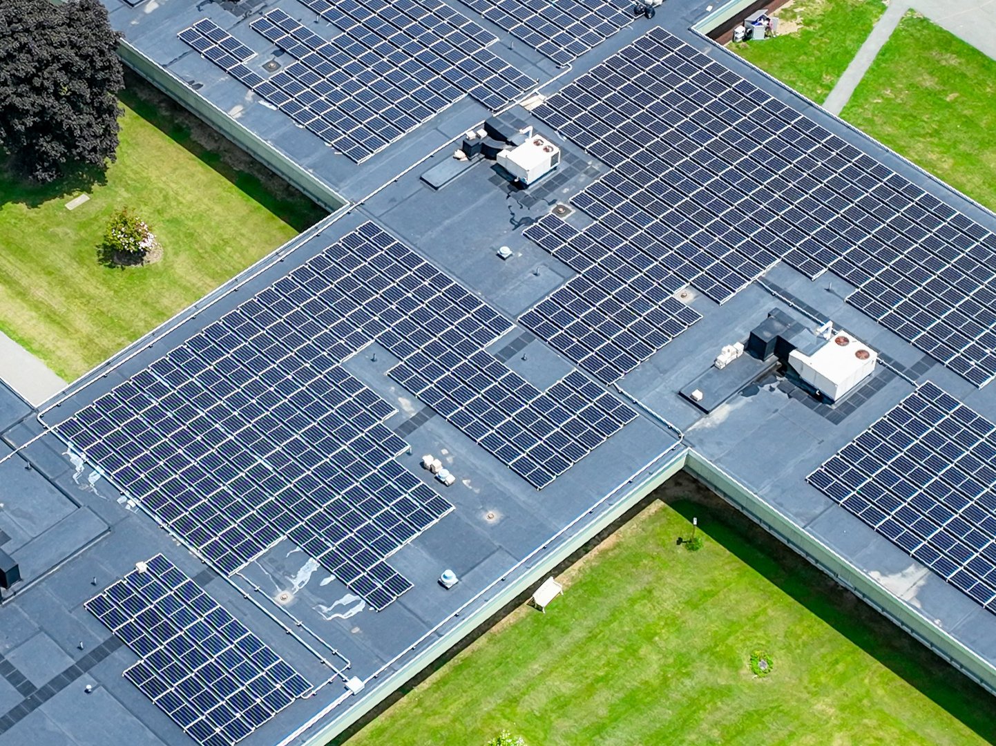 Photo solar panels install on a flat commercial, industrial EPDM roof, with concrete ballast blocks.