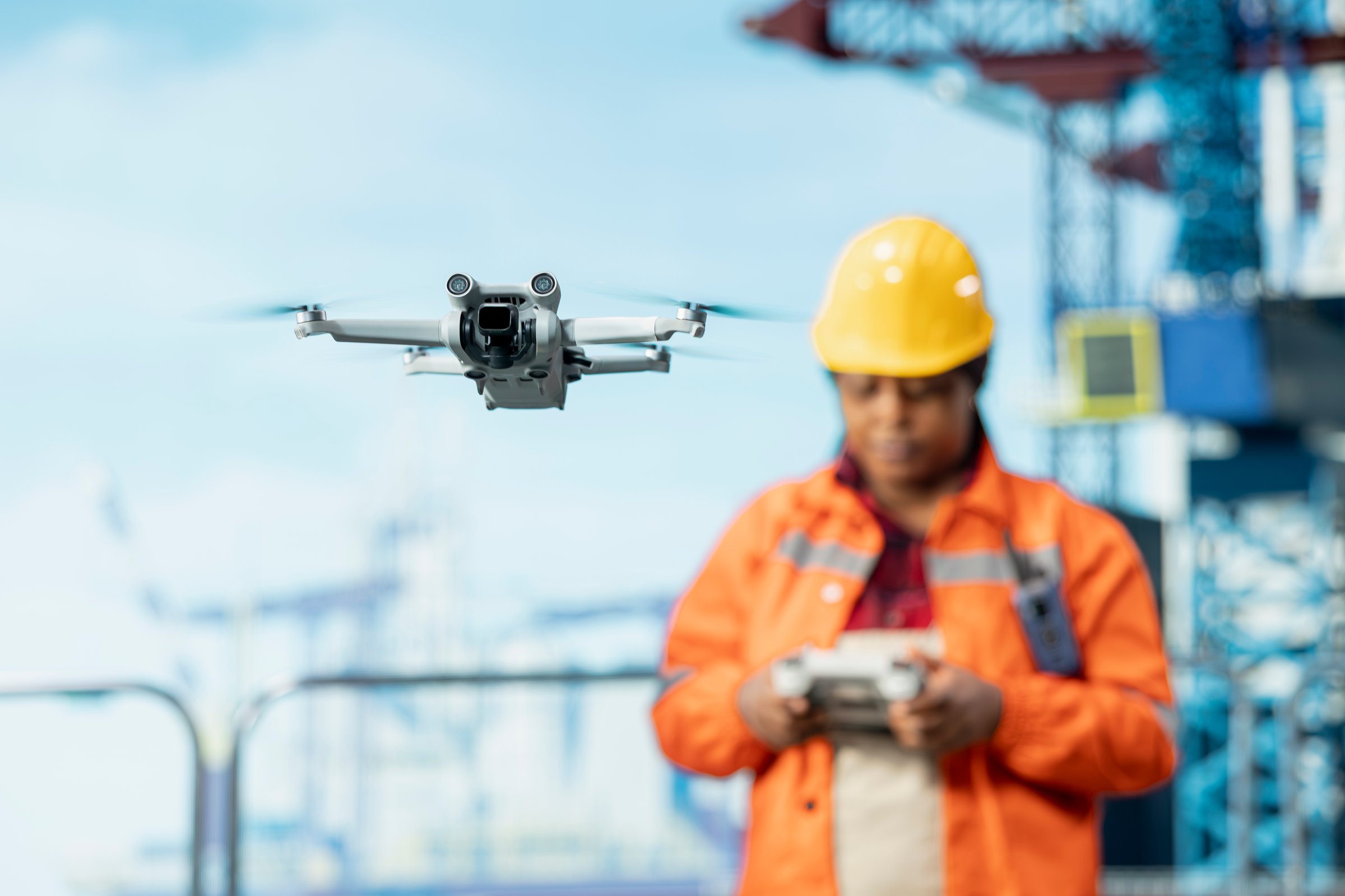Close up of drone used by drilling rig specialist to access areas that pose health risks to humans from safe distance. African american offshore platform employee use UAV to conduct aerial surveys
