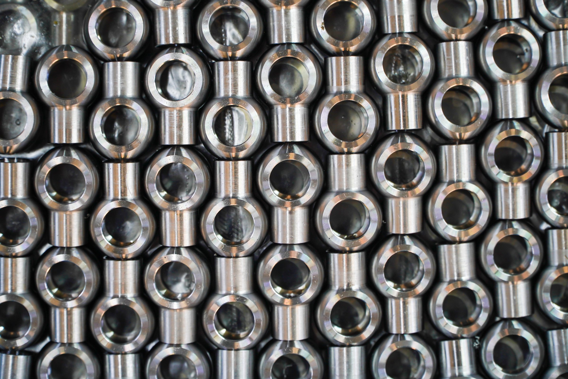 Shiny steel parts background. Regular industrial metal production pattern with selective focus.High precision steel automotive parts manufacturing by innovative CNC machining