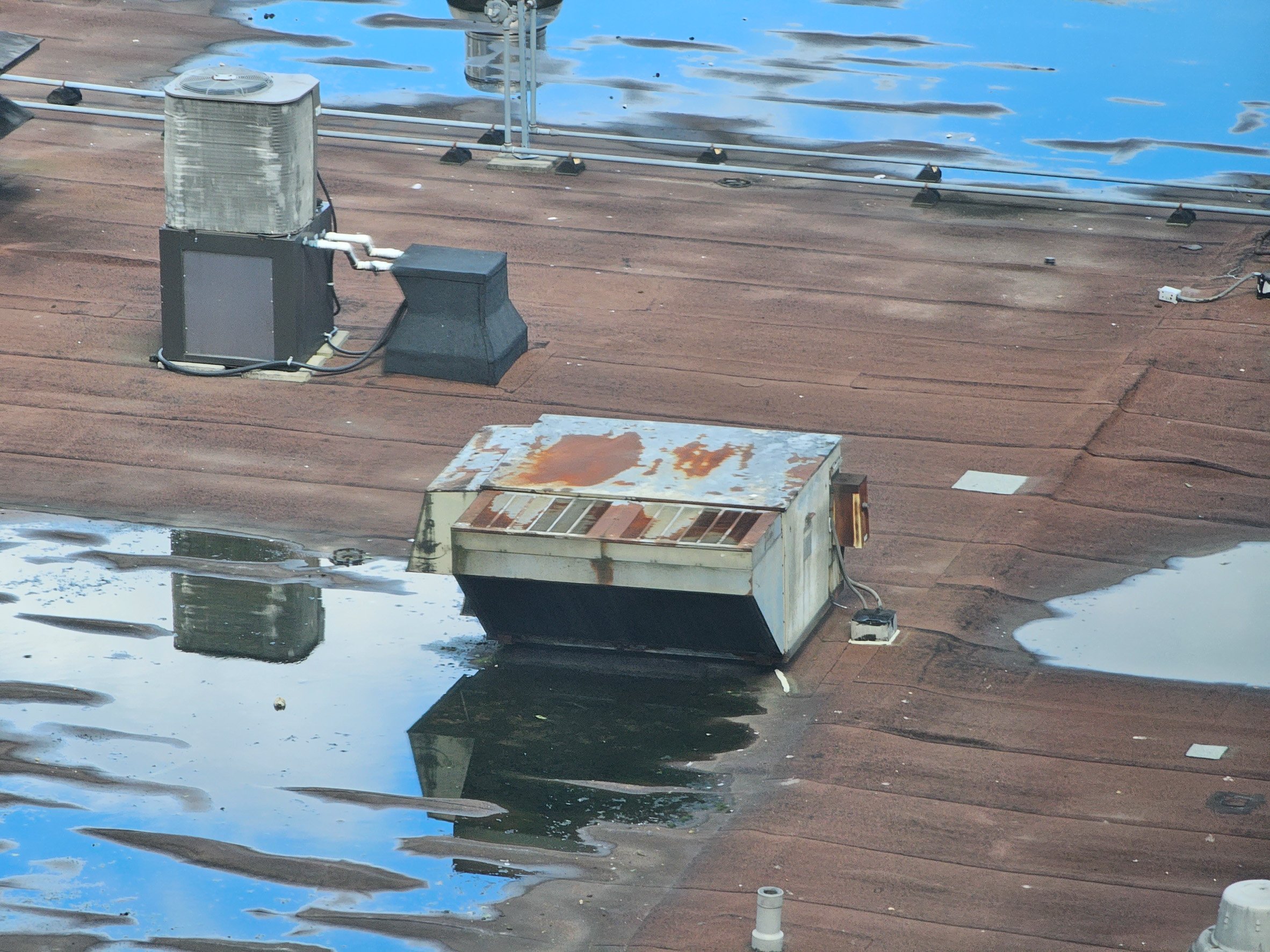 A closeup view of vents on the top of a wet roof.