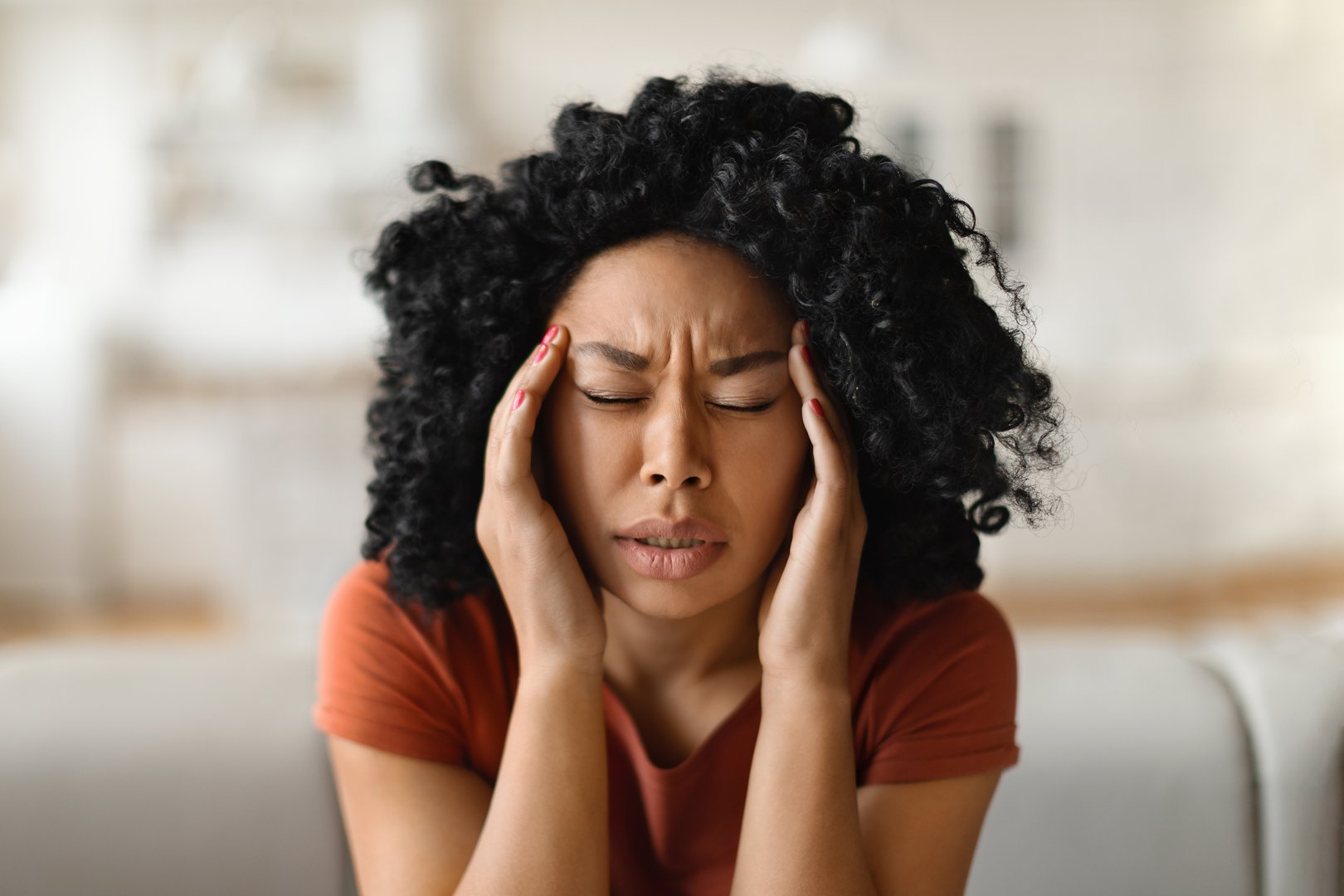 Migraine Concept. Closeup Shot Of Stressed Black Woman Touching Head With Hands, Young African American Female Massaging Temples, Suffering Acute Headache While Relaxing At Home, Free Space