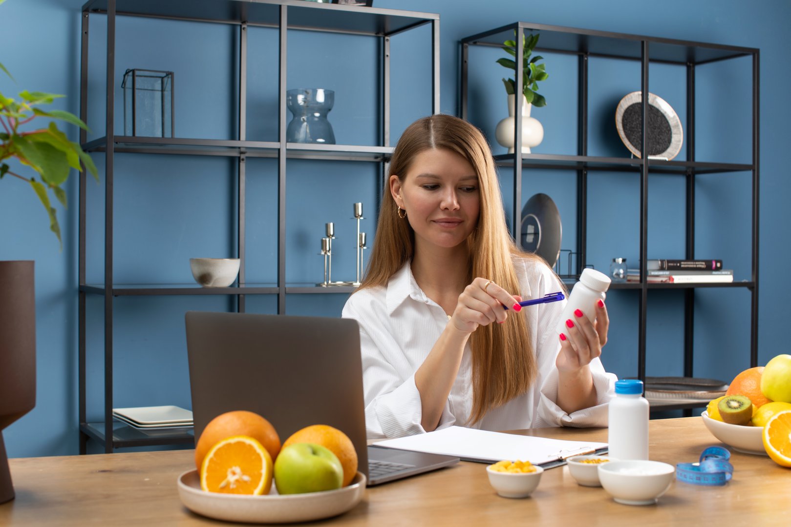 A young female nutritionist consults a patient online through a laptop on adding vitamins and nutritional supplements to a treatment plan.