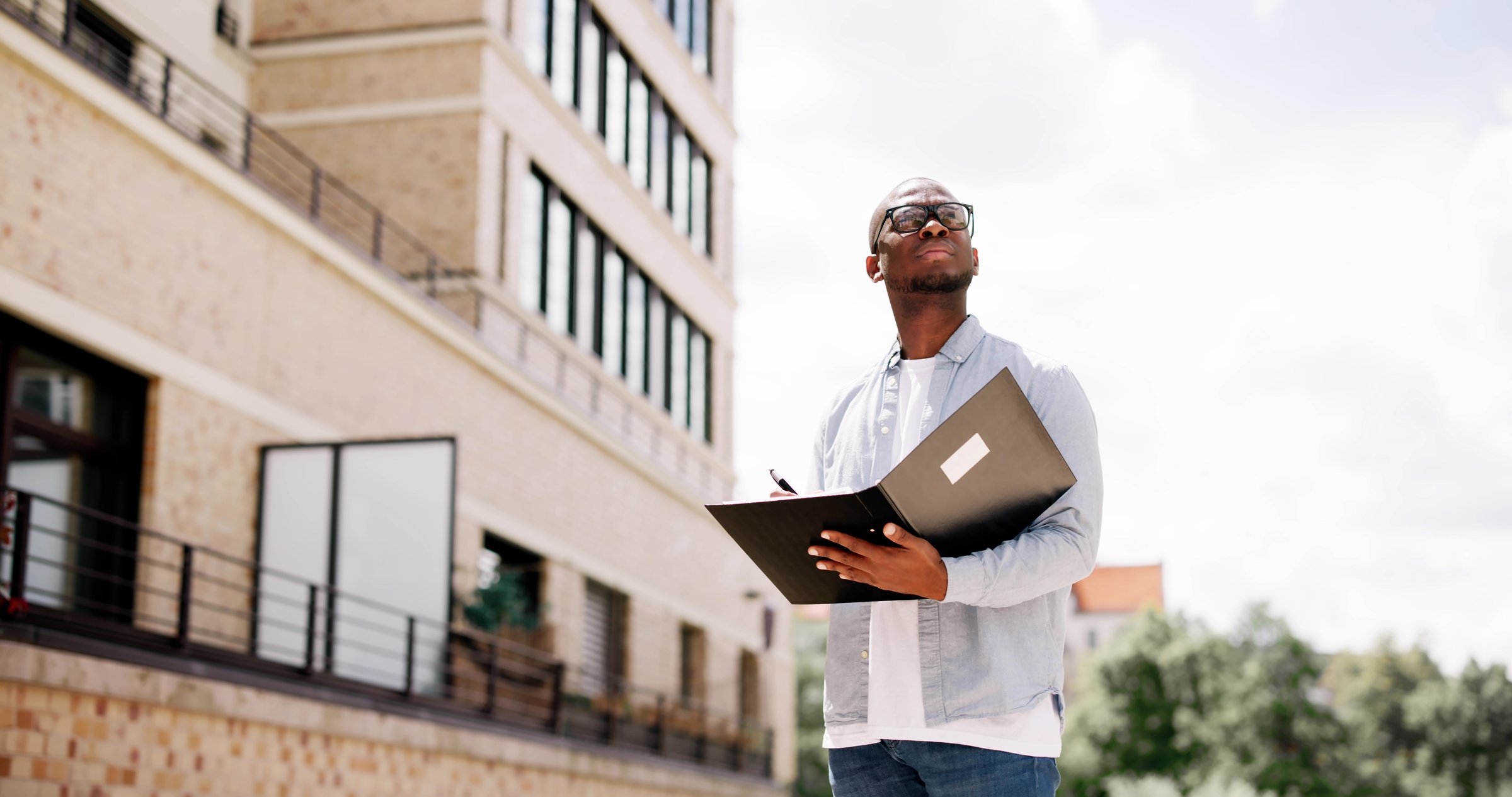 Young African American real estate agent inspects beachfront property in Boynton Beach, Florida for appraisal and potential sale. Business professional.