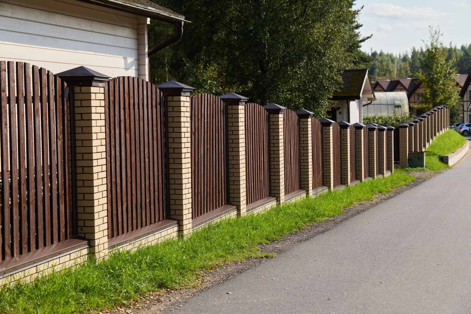 A beautifully crafted wooden fence enhances the serenity of a peaceful neighborhood, ideal for charming scenes
