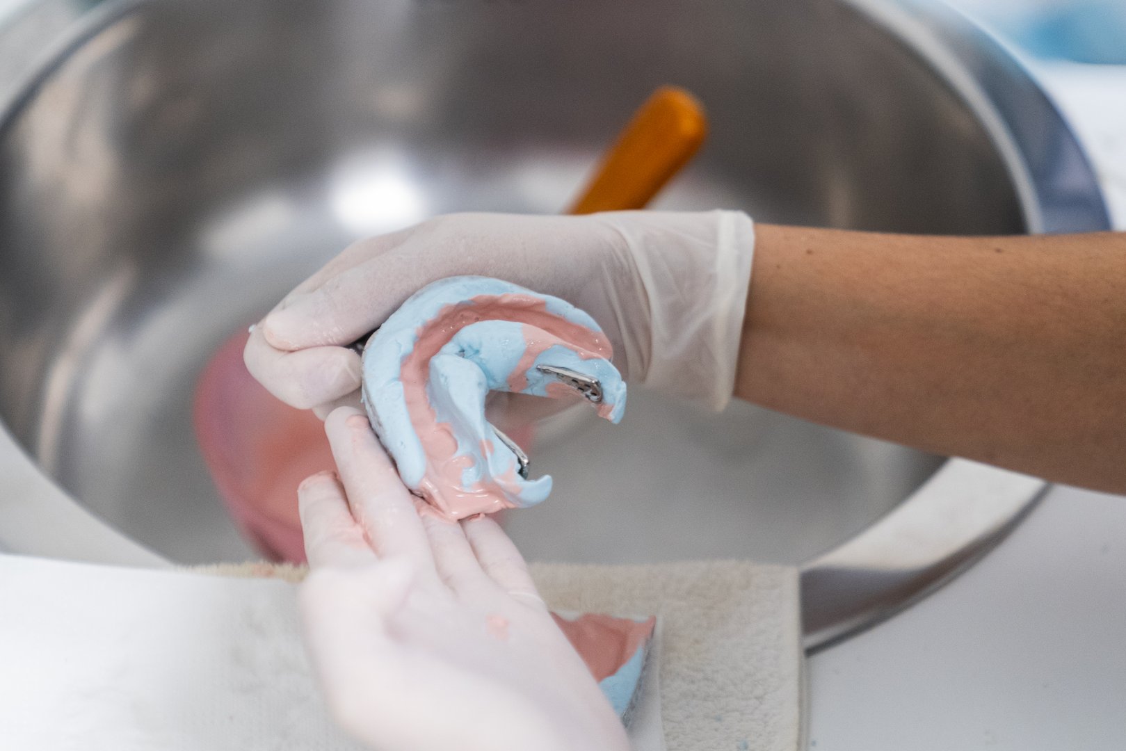 Dental technician preparing a dental mold in a laboratory