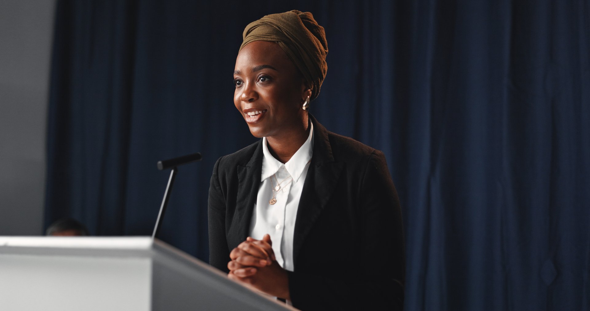 Black woman speaker at political convention with microphone