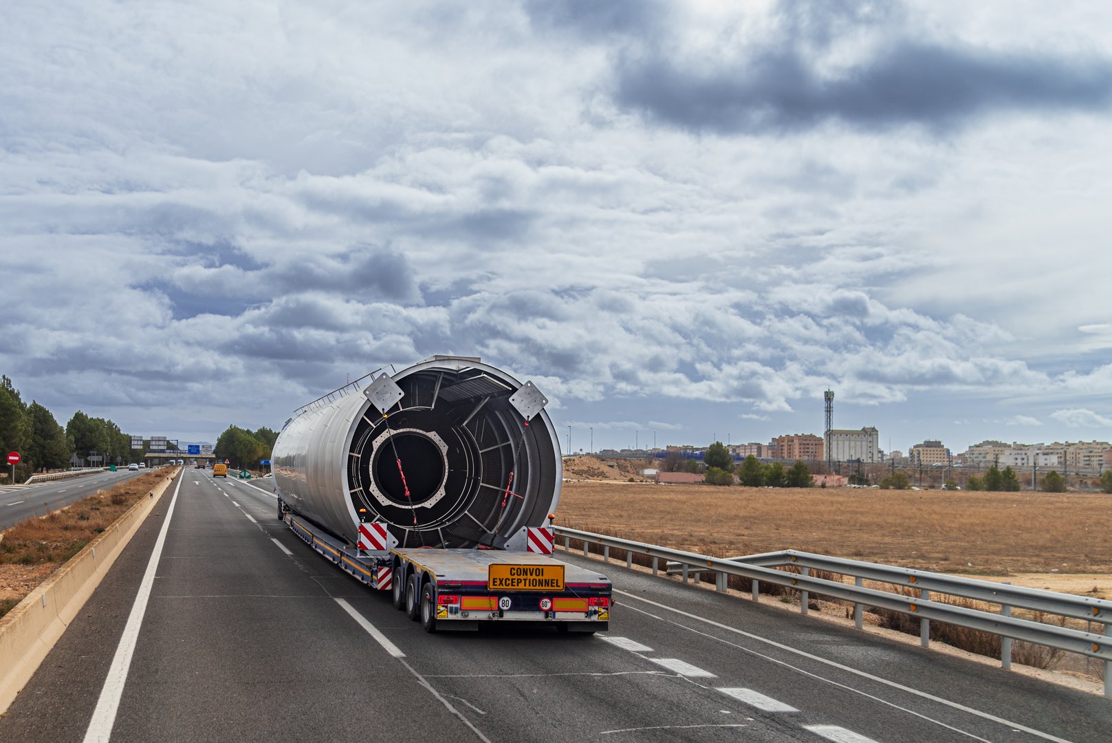Truck with oversized load driving on a highway.