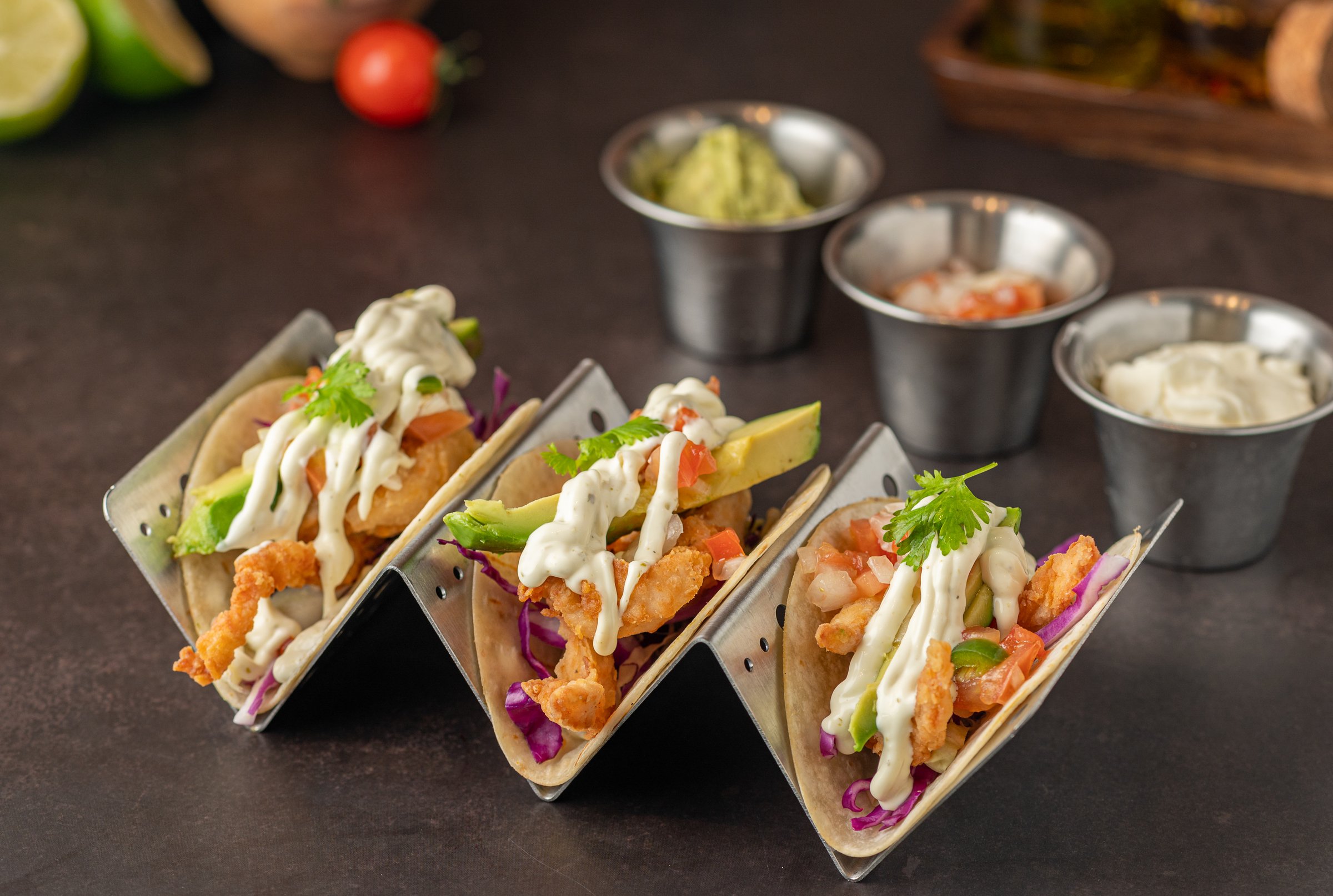 A closeup of tacos arranged on a black countertop