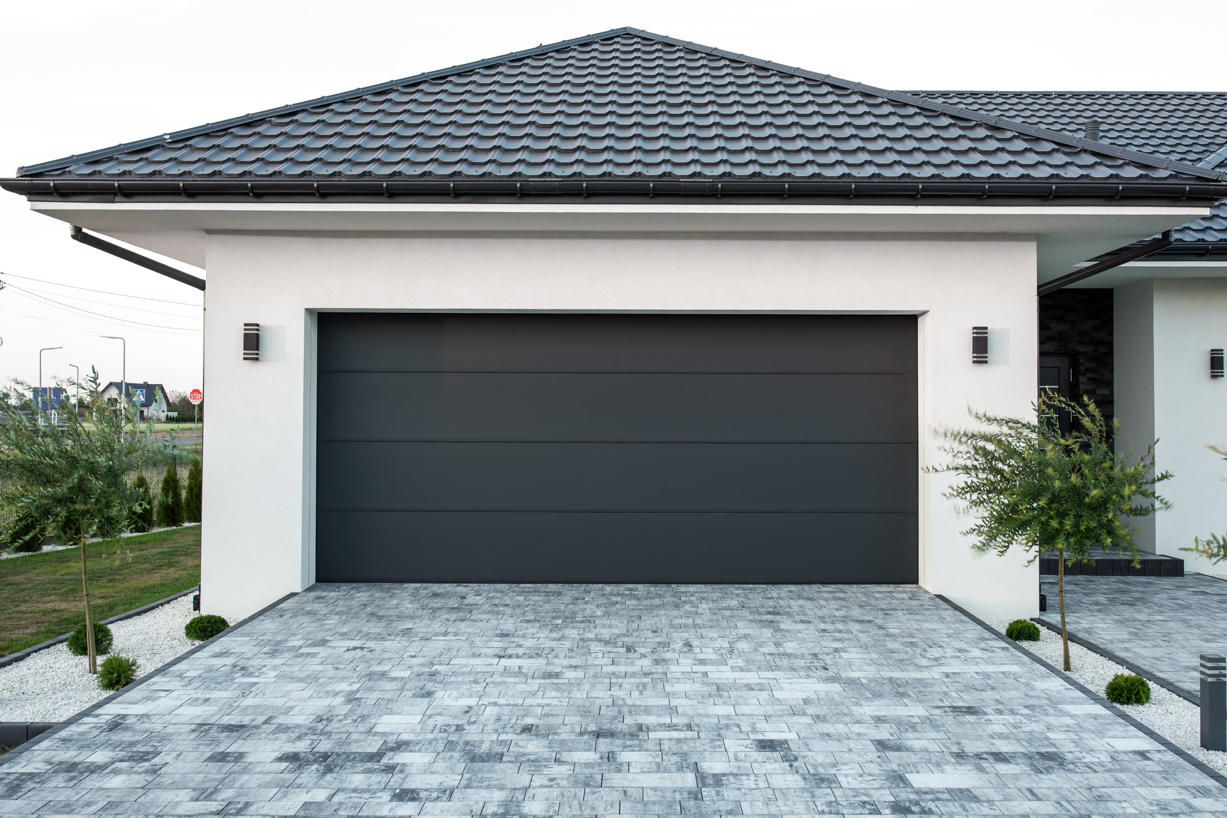 Facade of a modern garage. Designer entrance garage together with house Modern design. Luxurious exterior