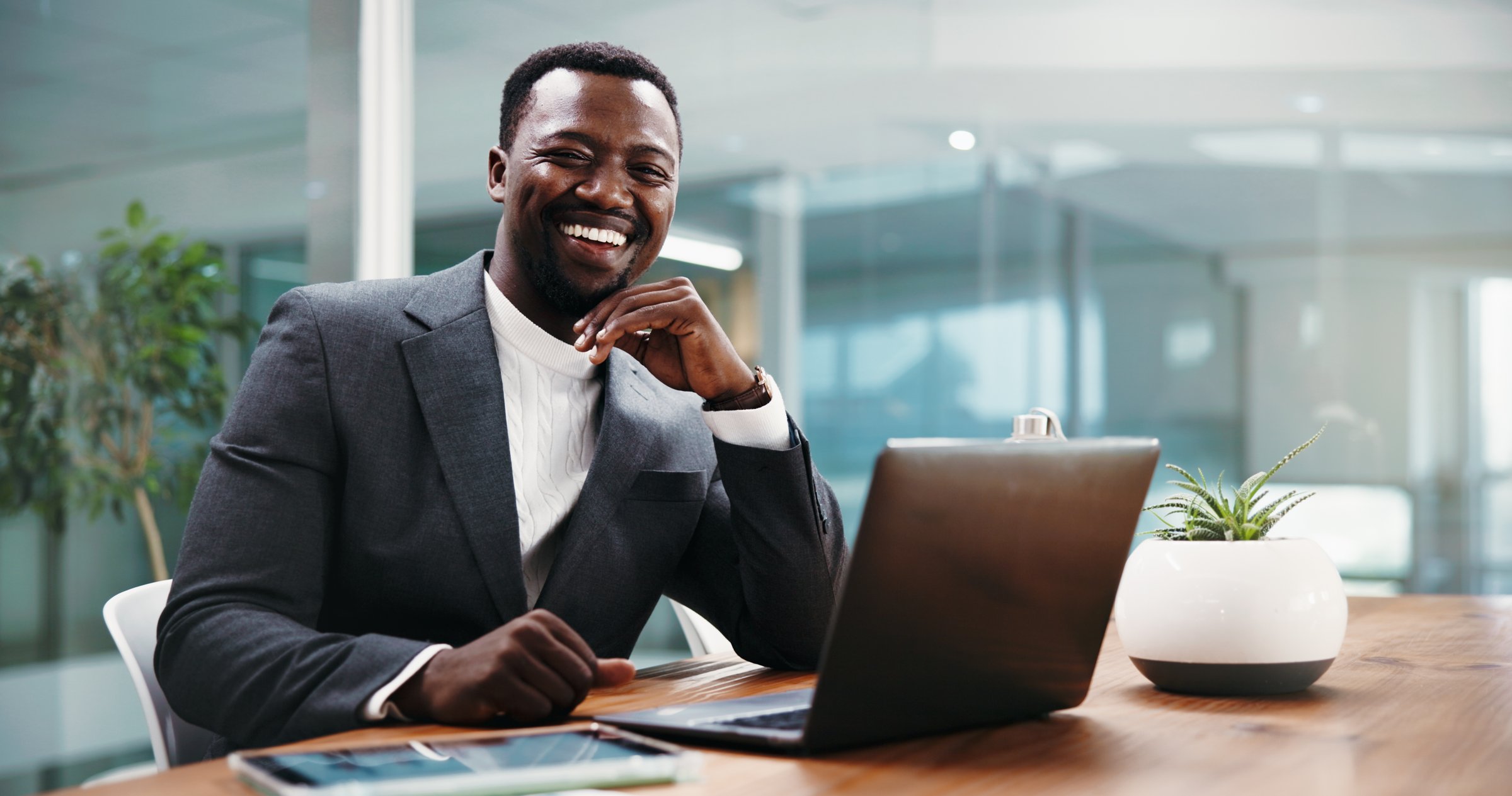 Portrait, business and black man laugh with laptop in office as corporate wealth consultant. African person, computer and confident worker with smile, about us and funny financial advisor from Kenya