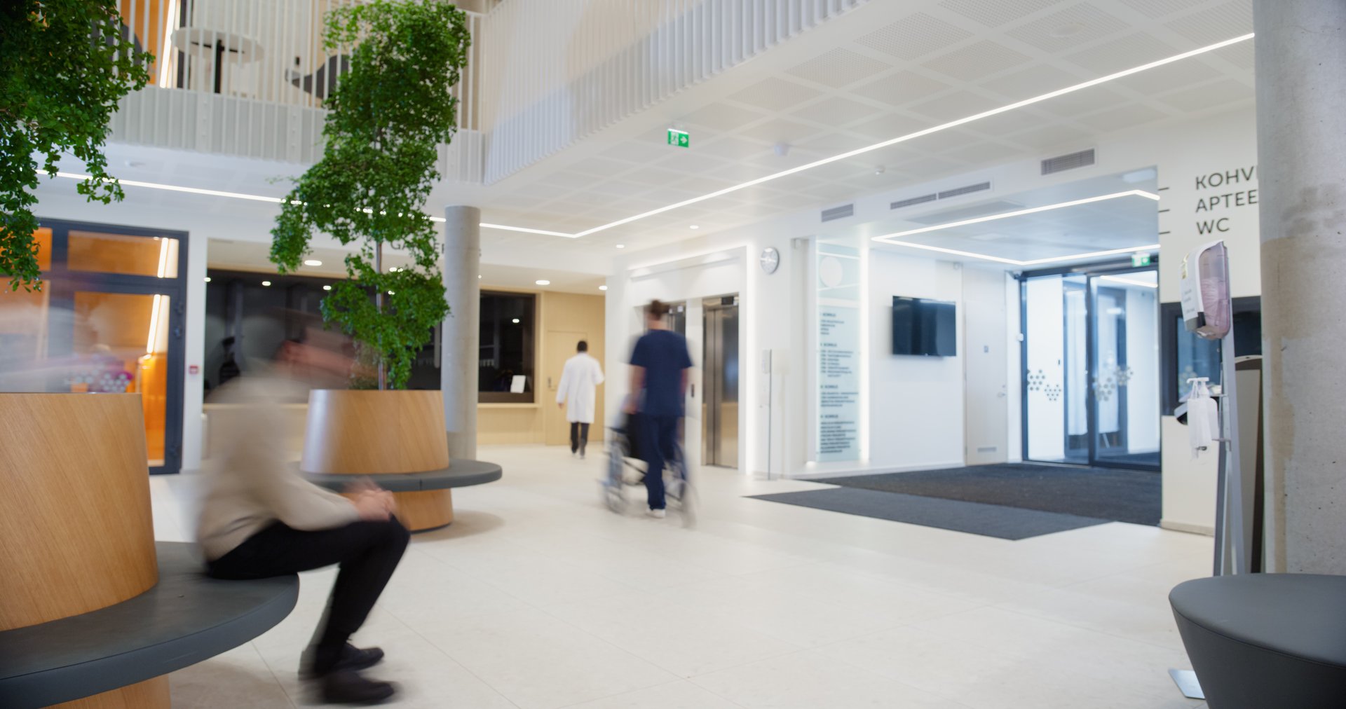 Motion Blur in Modern Hospital Lobby with a Busy Flow of Patients, Visitors, and Staff. Doctors, Nurses and Specialists Working in Clinic. Female and Male Healthcare Officials Walking in a Hall