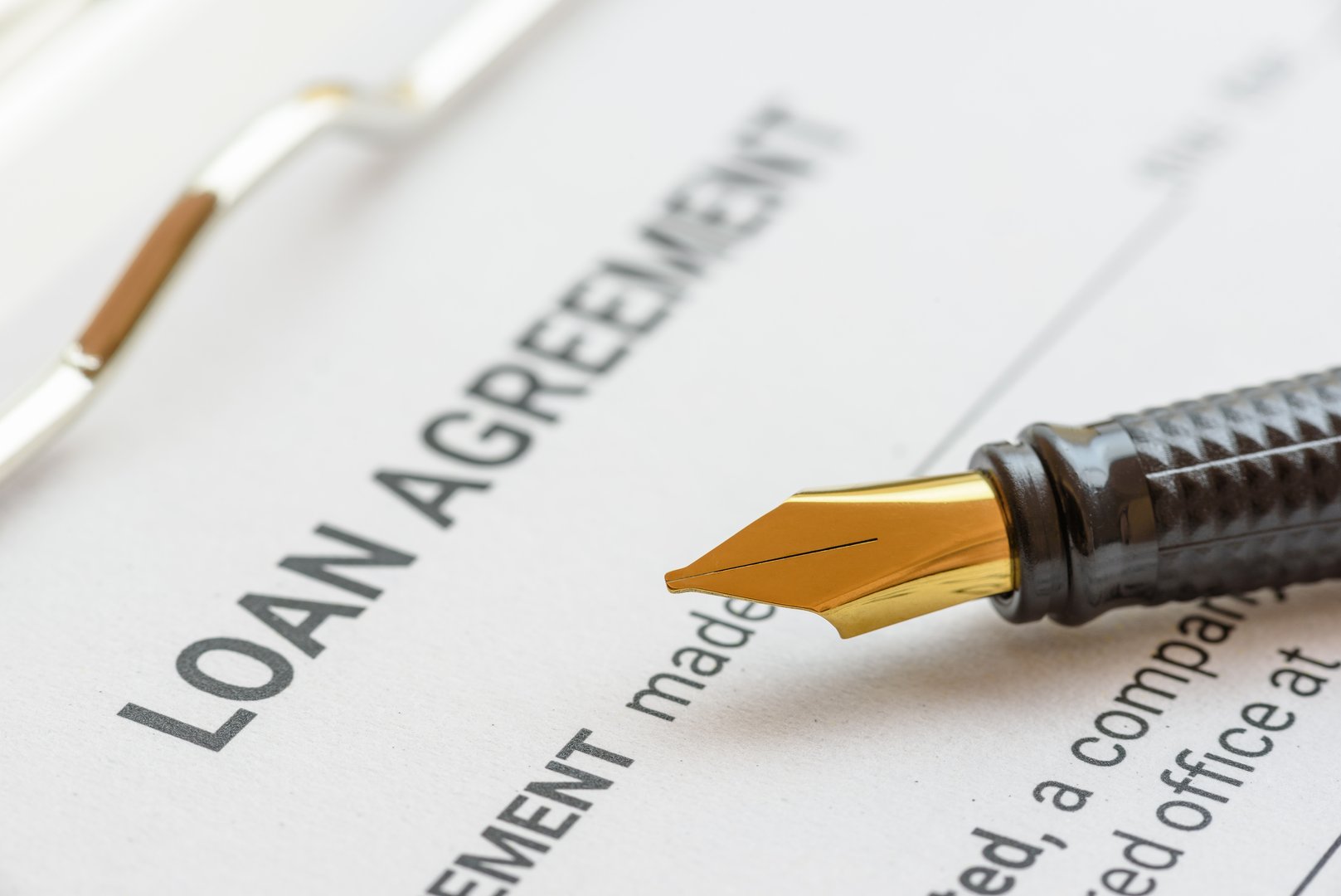 Business loan agreement or legal document concept : Fountain pen on a loan agreement paper form. Loan agreement is a contract between a borrower and a lender, a compilation of various mutual promises.