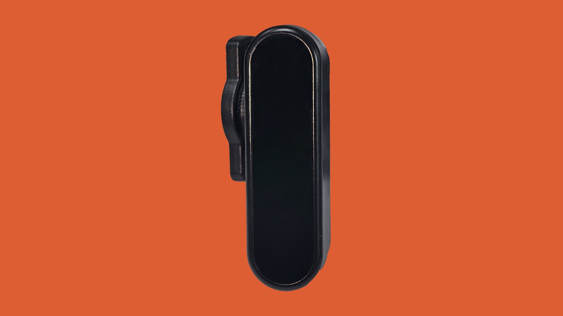 Black clip-on device against an orange background, with an oval shape and smooth finish.