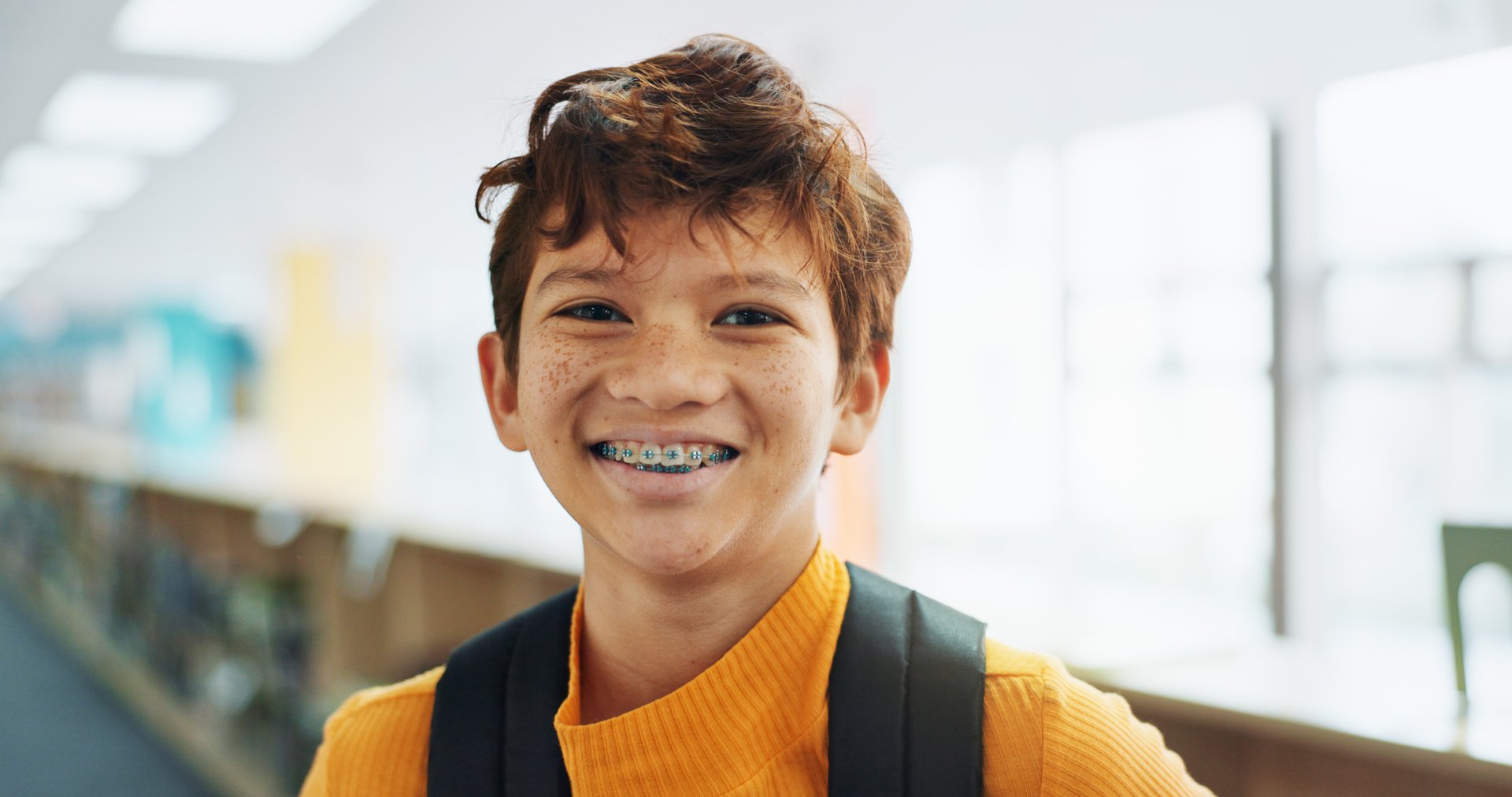 Portrait, knowledge and boy with braces, student and confidence with smile, pride and learning academy. Face, happy kid and childhood with backpack, studying opportunity and campus with education