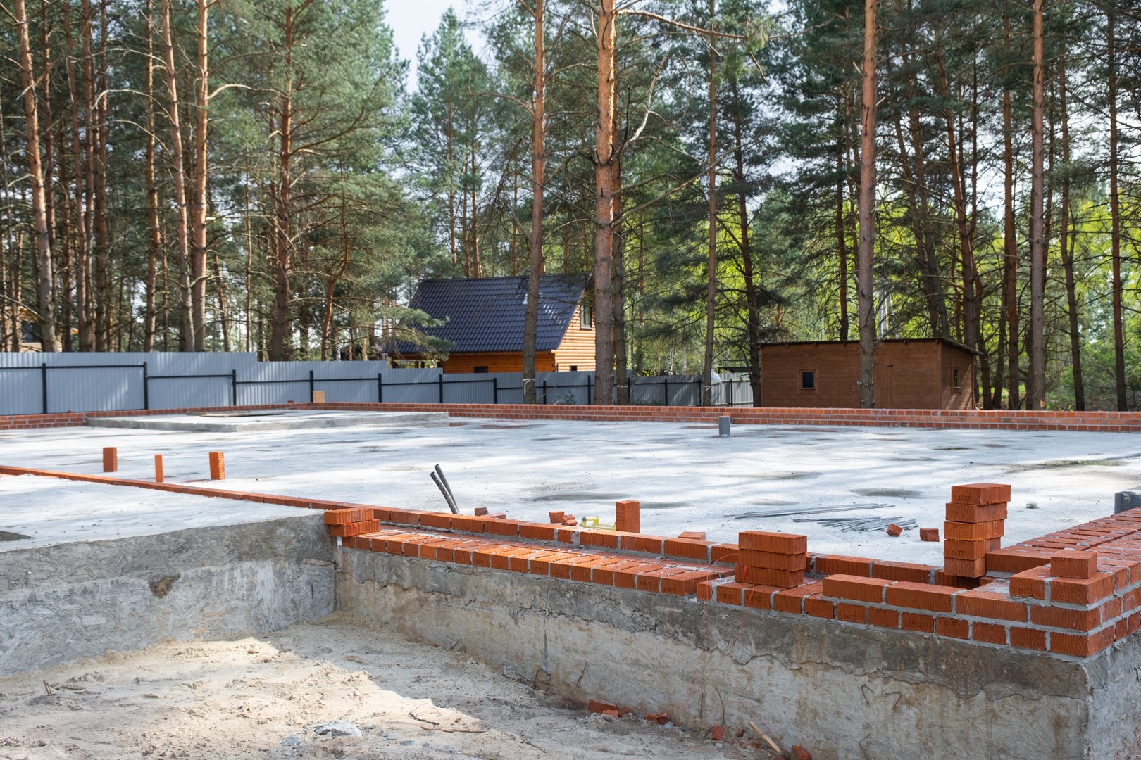 Concrete slab of foundation of house with laid pipes start of construction on project. Construction of cottages, design, engineering communications.
