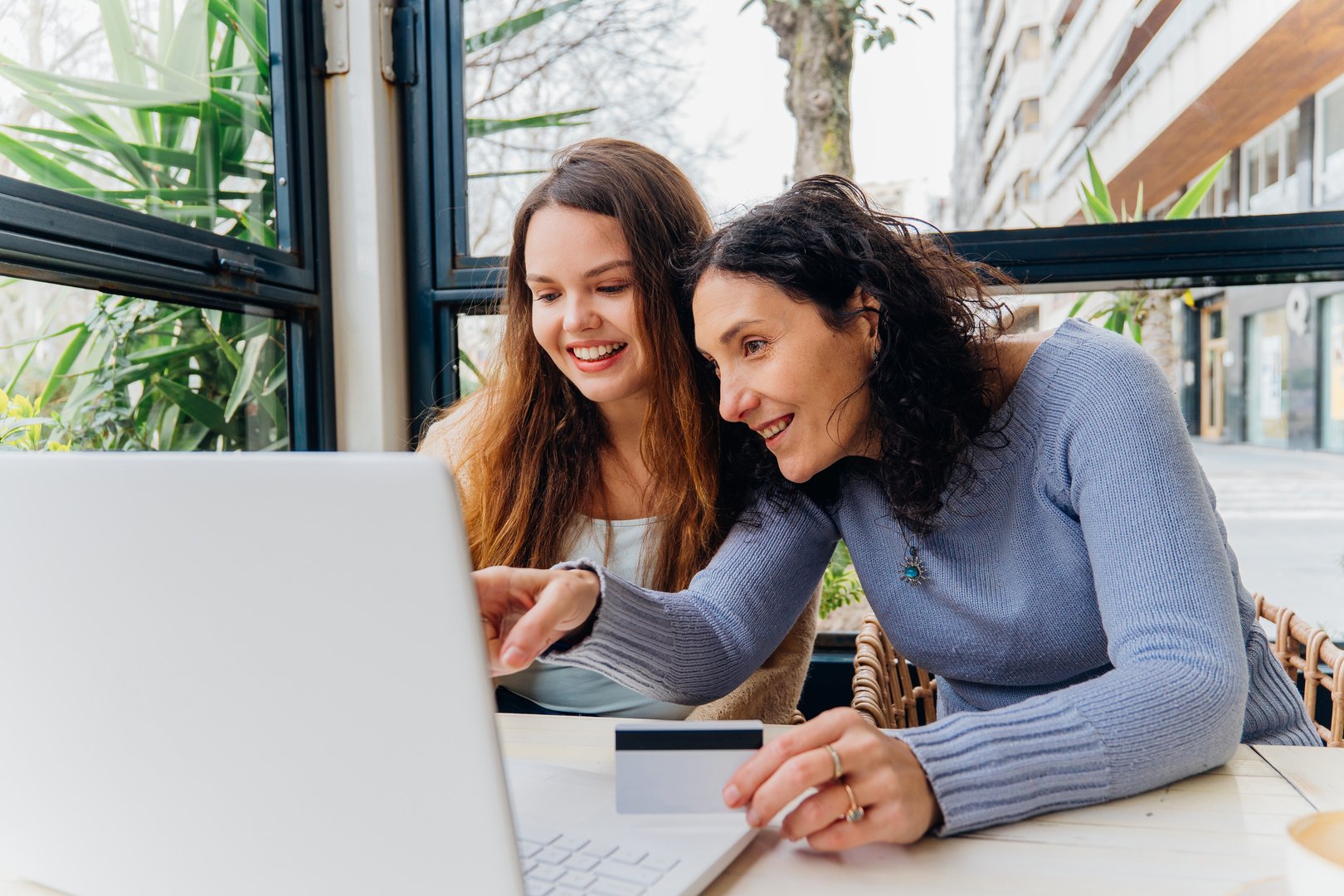 Adult daughter having conversation with elderly mother at home