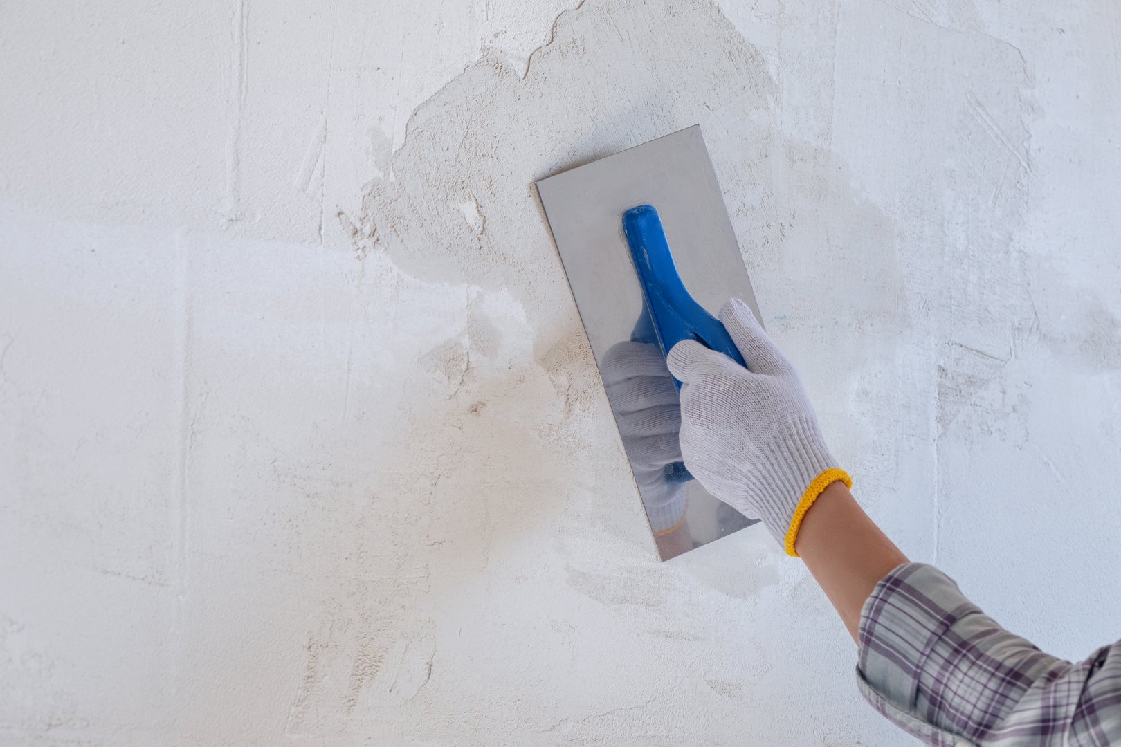 Plastering the wall using a trowel and starting plaster. The process of applying the starting plaster to the wall using a trowel.