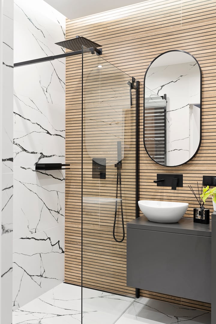 Home interior of modern bathroom with ceramic wash bowl on bathroom cabinet and circle mirror on the wall. Luxury and elegance in hotel. Indoors architecture.