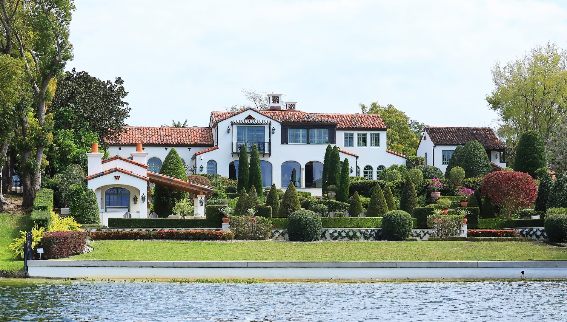 Winter Park, Florida, USA - March 8, 2025:  Beautiful manicured home and landscaping in the Chain of Lakes, as seen from a scenic boat tour.