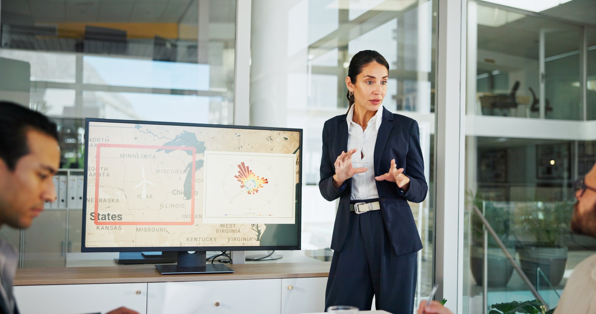 Business woman, screen and map with presentation for renewable or clean energy at conference. Female person, employee or speaker talking with technology display for wind turbine or global development